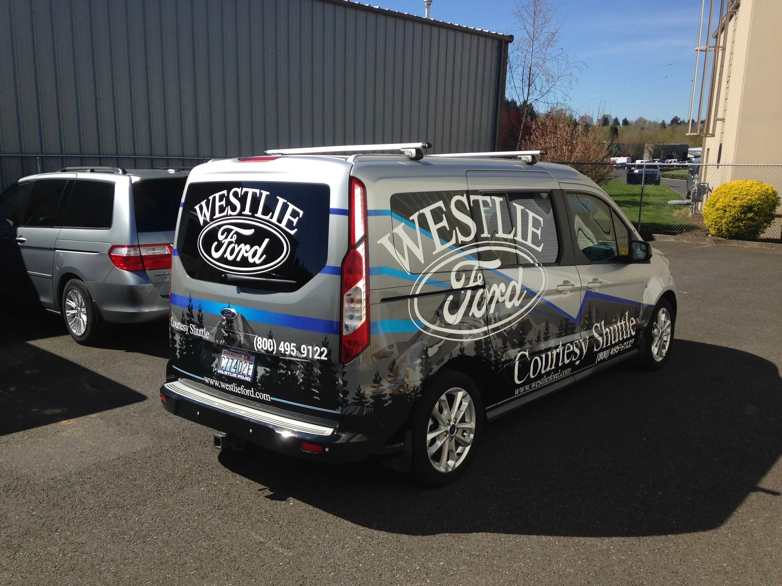 WESTLIE FORD 1: -Partial wrap using plotted printed c-tac with luster laminate and cut vinyl. The client wanted to keep the project cost as low as possible, while attaining a full wrap look. I designed the graphics to include affordable, large, cut vinyl logos to cover the windows, kept the color palette in the same family as the actual body color of the vehicle so that the graphics would blend effortlessly.