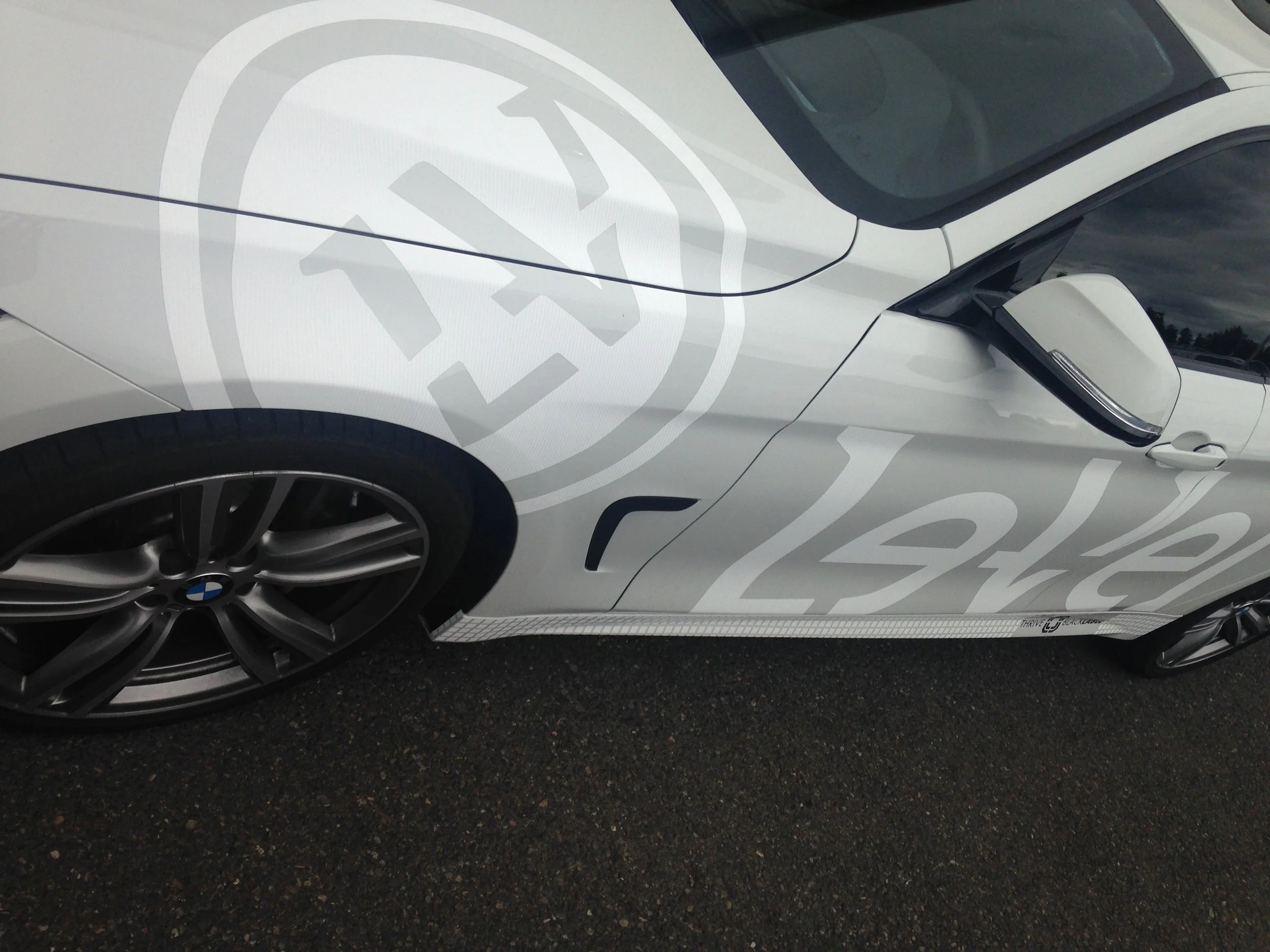  LEVEL 1:  -Partial wrap using 3m matte white carbon fiber vinyl w some c-tac. The client wanted a classy graphic that would promote his brand of nutritional supplements without being too loud. The white on white graphic provides enough contrast to b