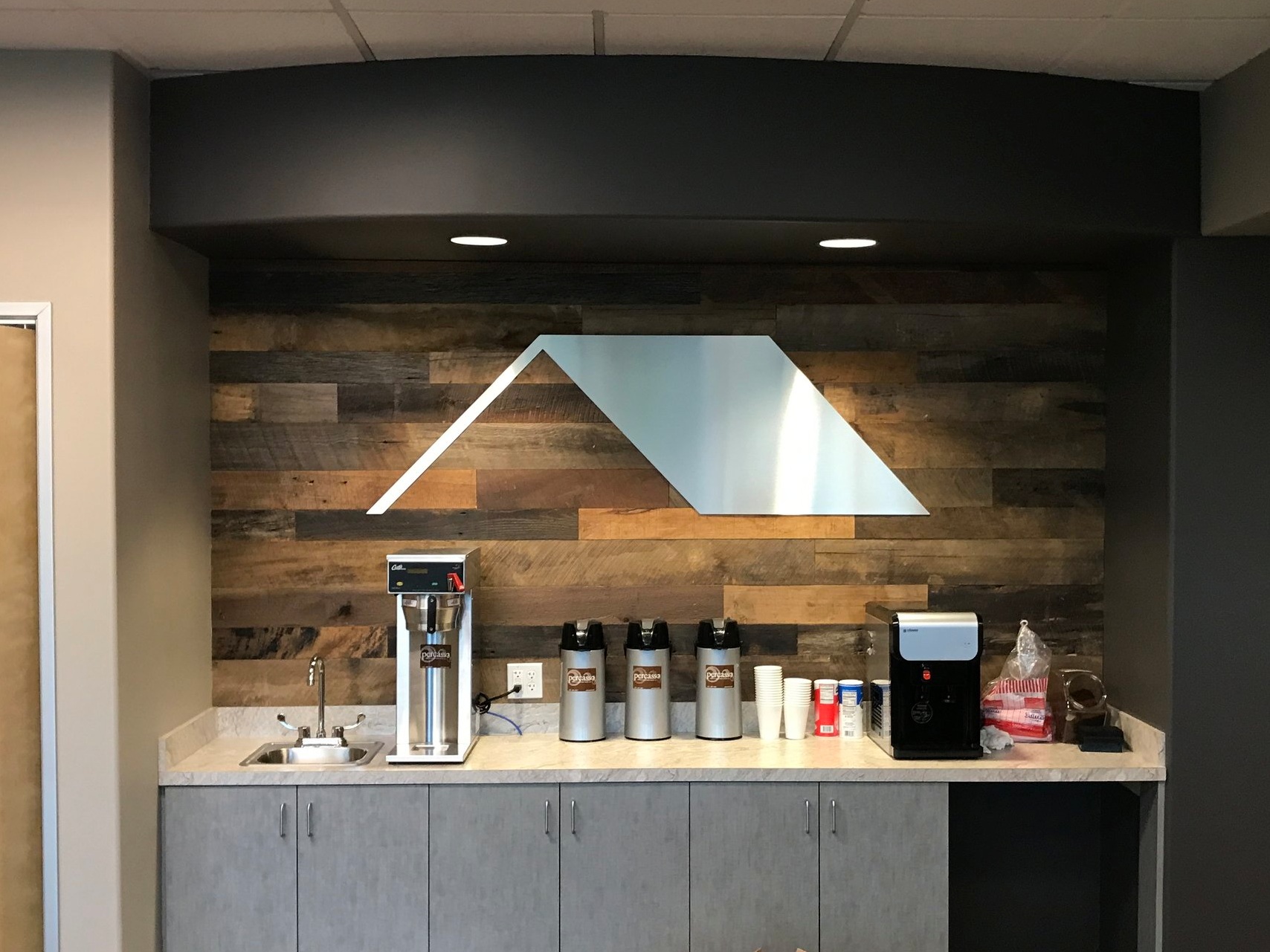 SHELTER PRODUCTS: -Routed, brushed aluminum DiBond dimensional logo mounted unto reclaimed barn wood backer.