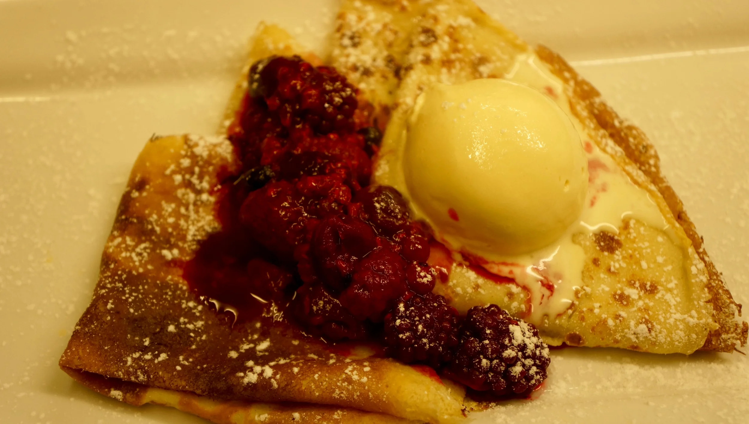 Pancakes with warm berries and vanilla clotted ice cream