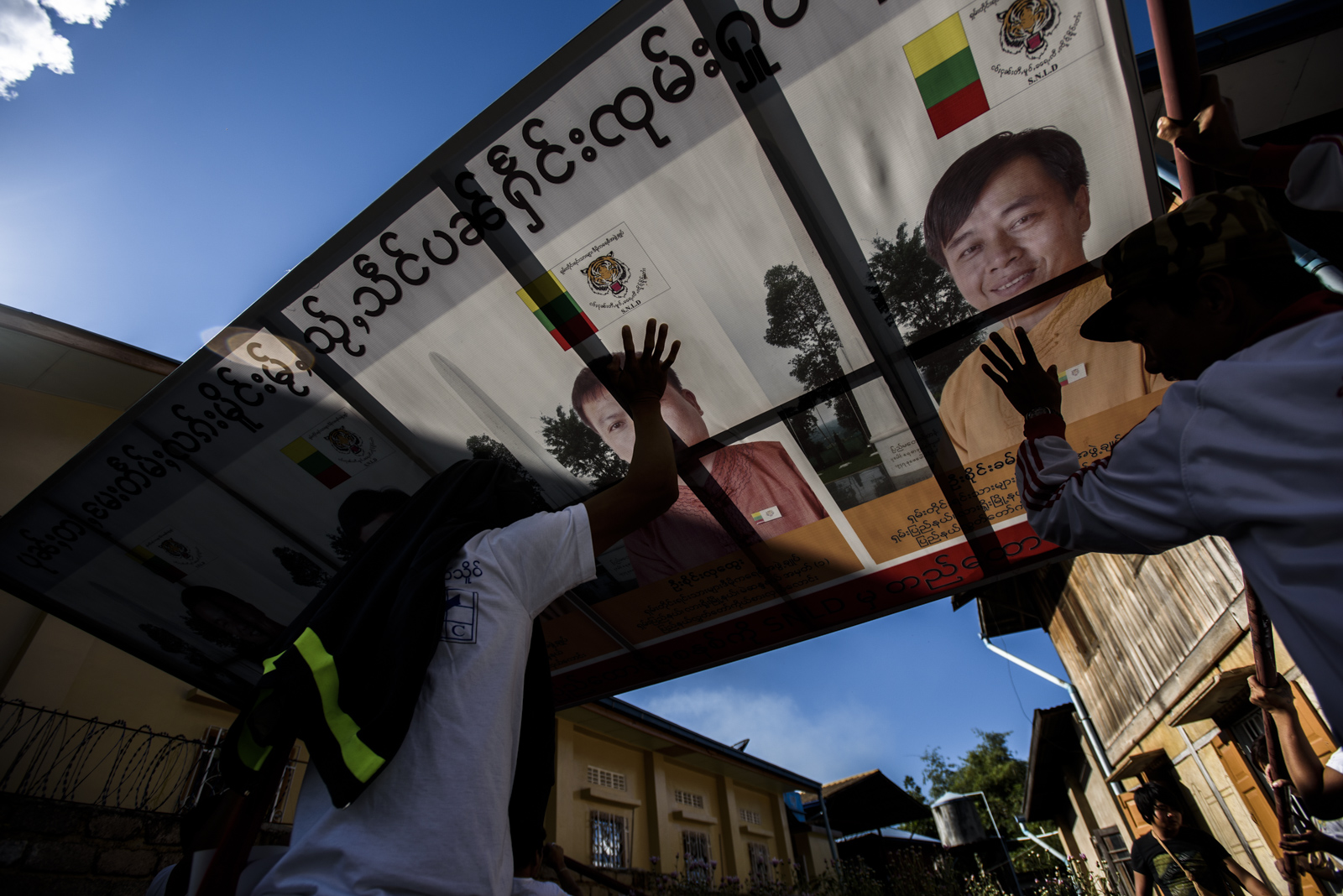 A campaign sign is taken down. The election commission declared a "day of rest" the day before the election, with no campaigning and materials removed from public spaces.