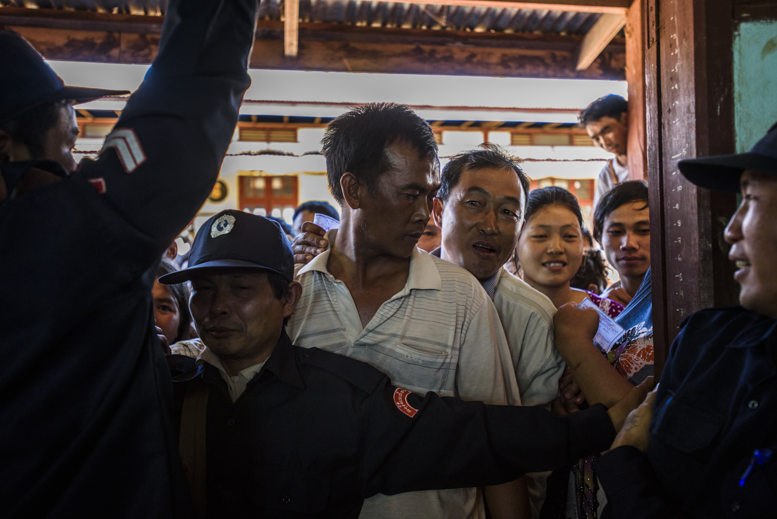 Security officers hold back a horde of voters at a polling station in One Leng's district in Lashio, Myanmar.