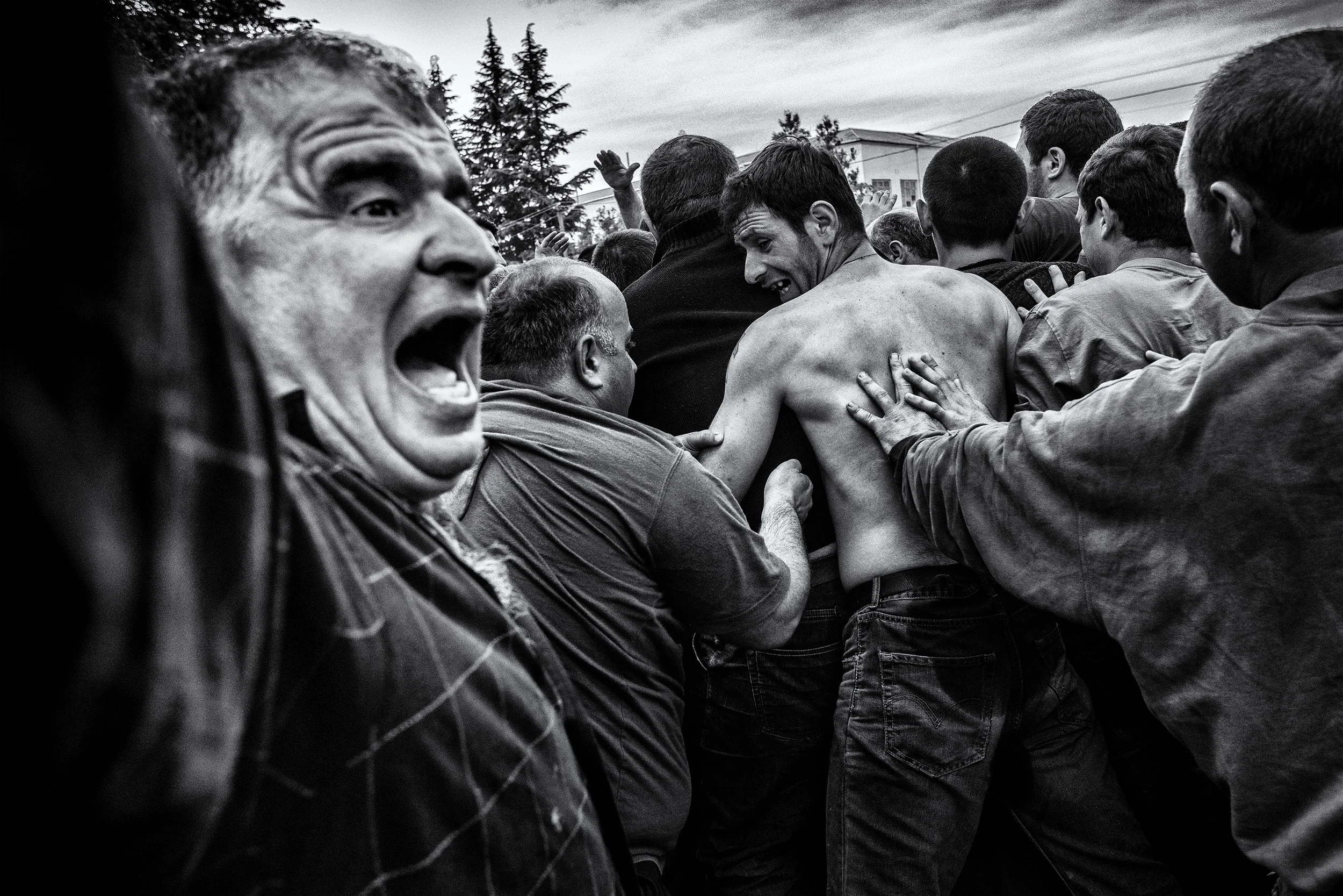 Usually the ball is not seen during the whole game as a melee is always on top of it. Despite its 16 kilo weight, men carried as it was a regular rugby ball. People falling, pushing, shouting. The brutality is part of the no rules game. Shukhuti, Georgia, April 2014.