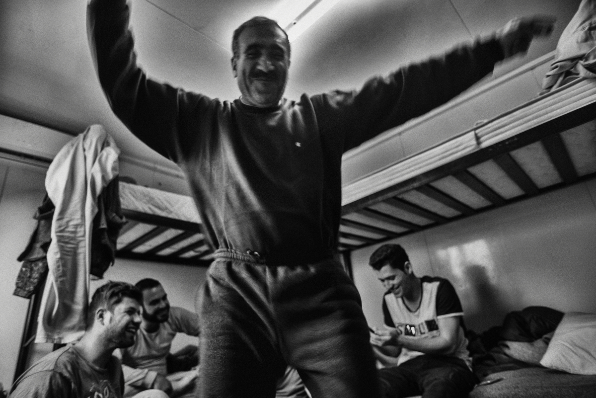  S. is dancing inside a bunkhouse in Eleonas, a government owned camp for refugees in Athens.&nbsp;In order to avoid the registration process S. prefers to sleep on the streets than inside the camp but still he comes everyday to talk with friends and