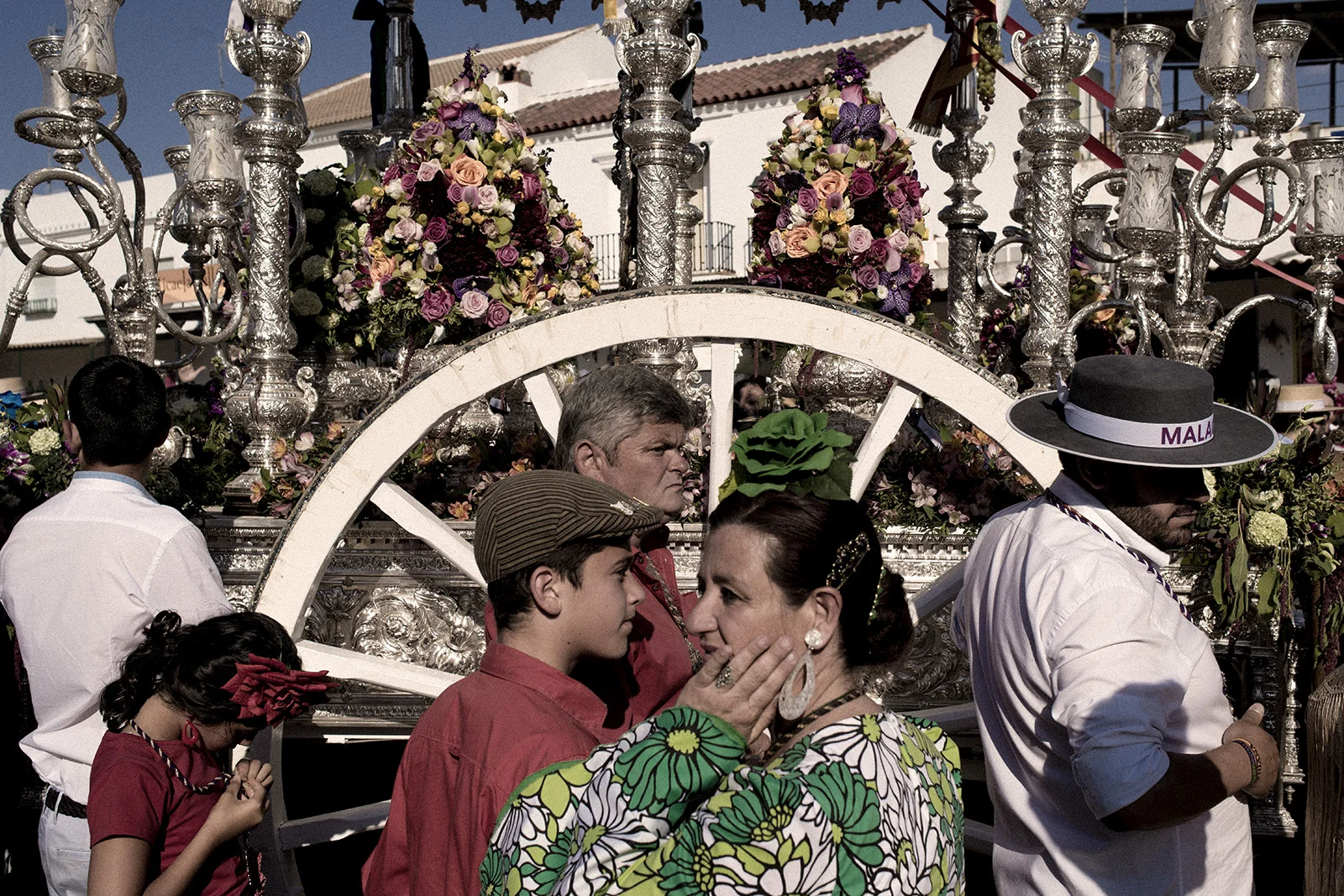 Each brotherhood's "simpecado" wagon has to be carried in front of the hermitage to venerate the Virgin of El Rocío before Sunday's big ceremony. Despite the sandy roads and the high temperature most people doing the procession is wearing traditional andalusian costumes. El Rocío, Spain, May 2015.