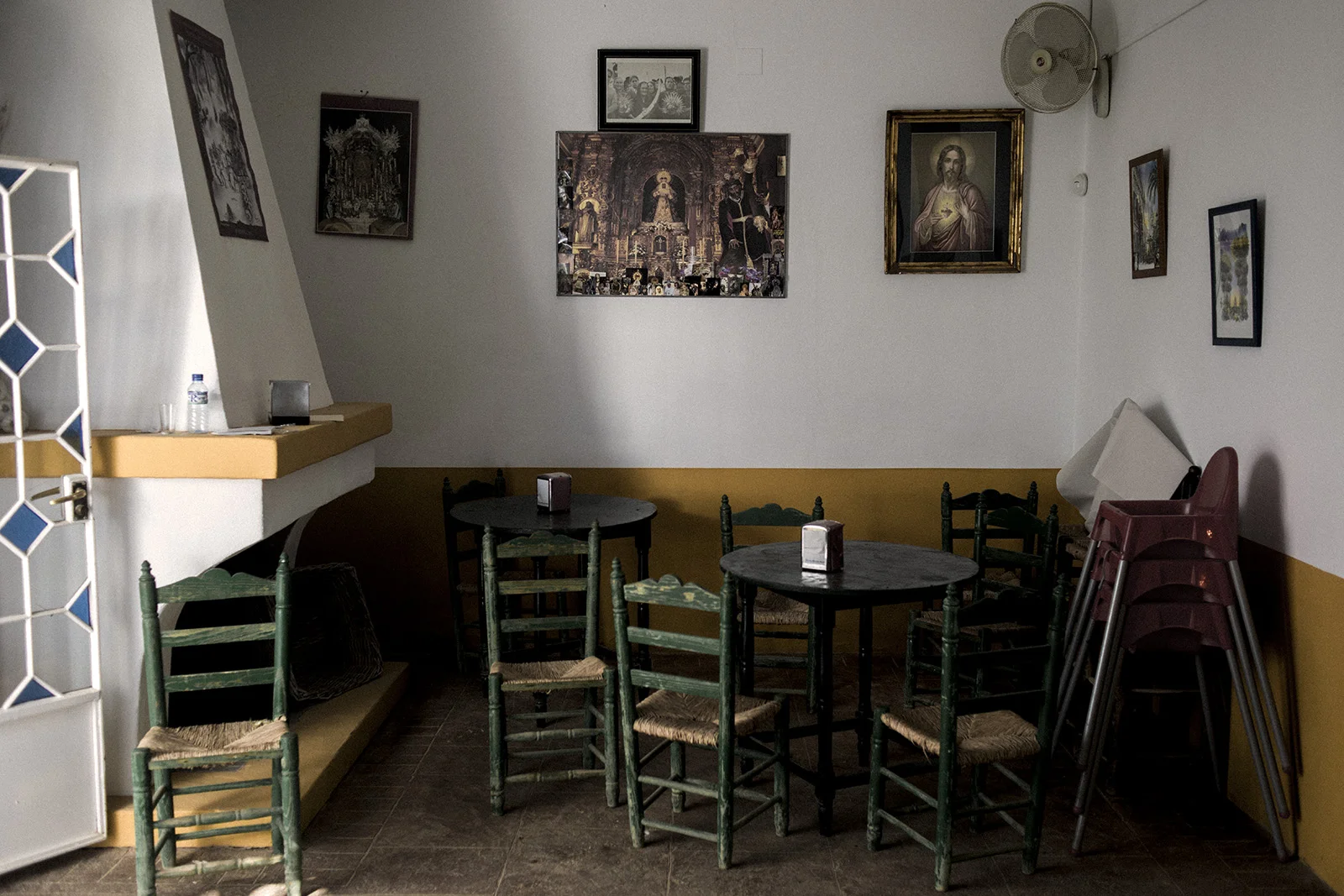An inside view of a bar in El Rocío decorated with various catholic iconographies. Despite being inside one of the biggest National parks in Spain, Doñana, this town focus all of its tourism during all year around religion. El Rocío, Spain, May 2015.