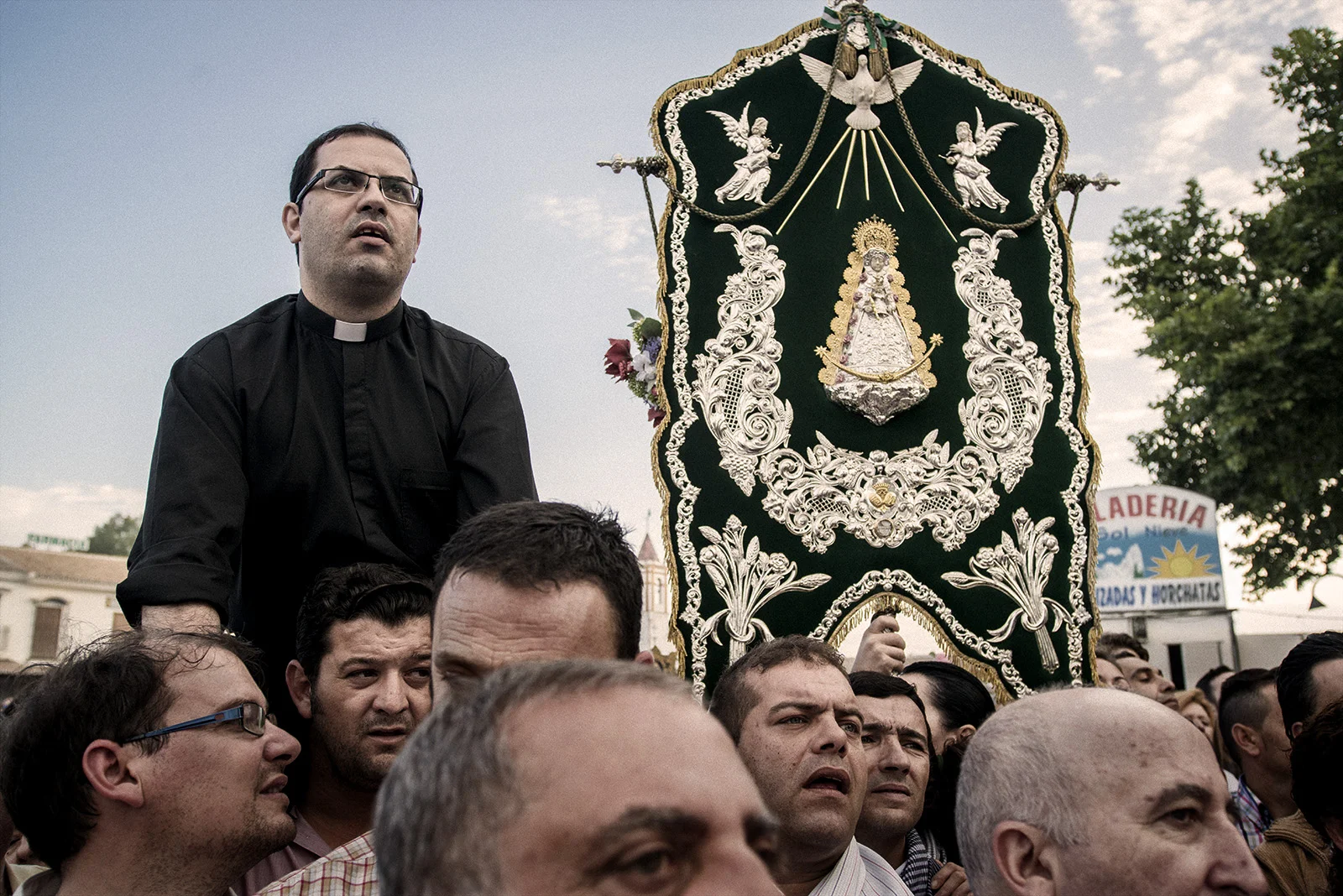 Almost each brotherhood doing the pilgrimage has its own priest with them. As the journey can be few days long, priests usually officiate ceremonies every morning during the travelling. El Rocío, Spain, May 2015.