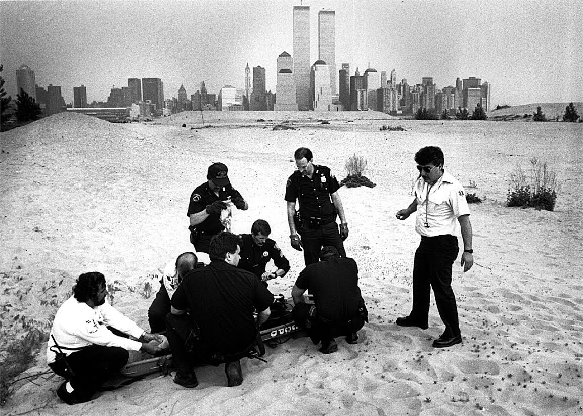 Jersey City Medical Center Paramedics work to resuscitate a youth who went swimming in the Hudson River and was brought to the surface by rescue divers. The "beach" on the Jersey City waterfront is all luxury housing now. Photograph by Bill Bayer. 