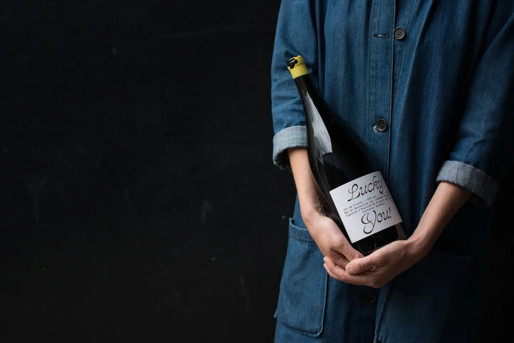 A person in a denim jacket holds a magnum of natural wine labeled 'Lucky You!'—the perfect pour for exclusive private parties at our Bristol venue