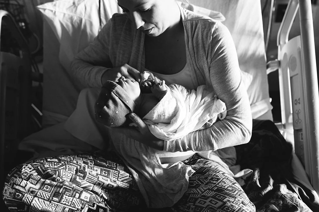 mother holding her one day old daughter in hospital