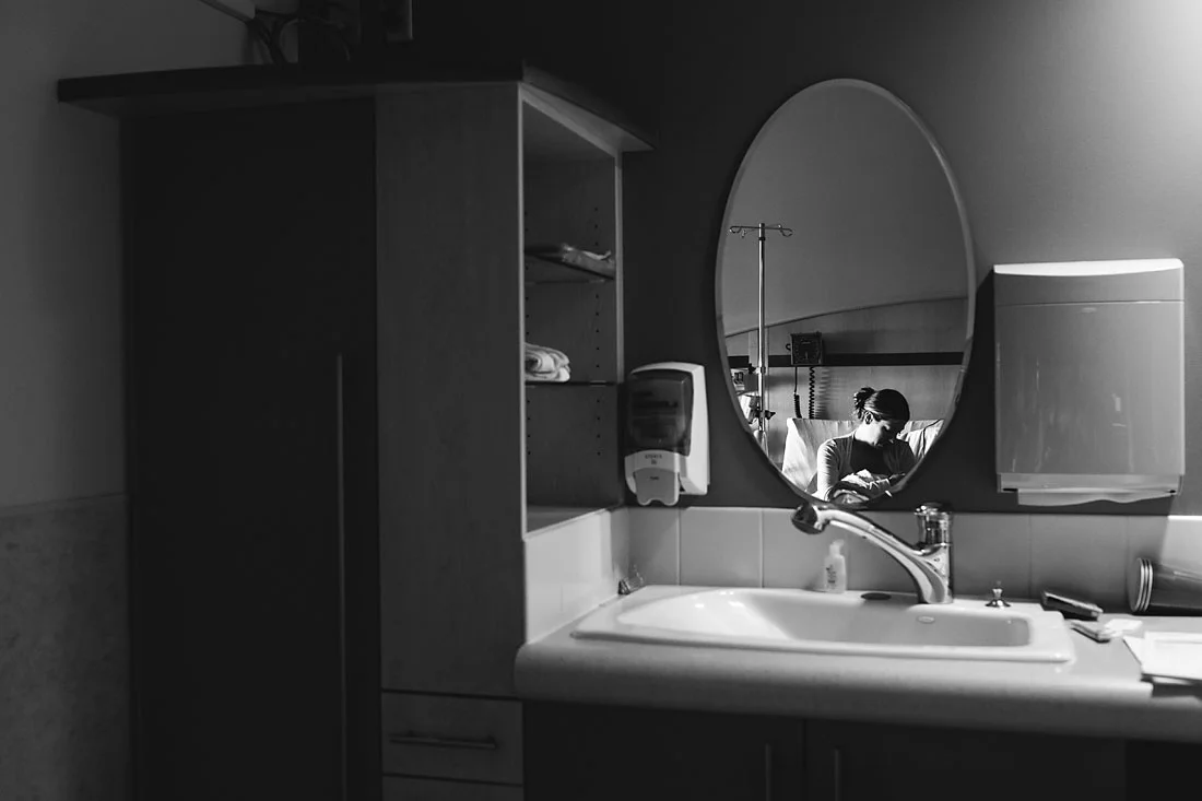 mother holding her one day old daughter in hospital