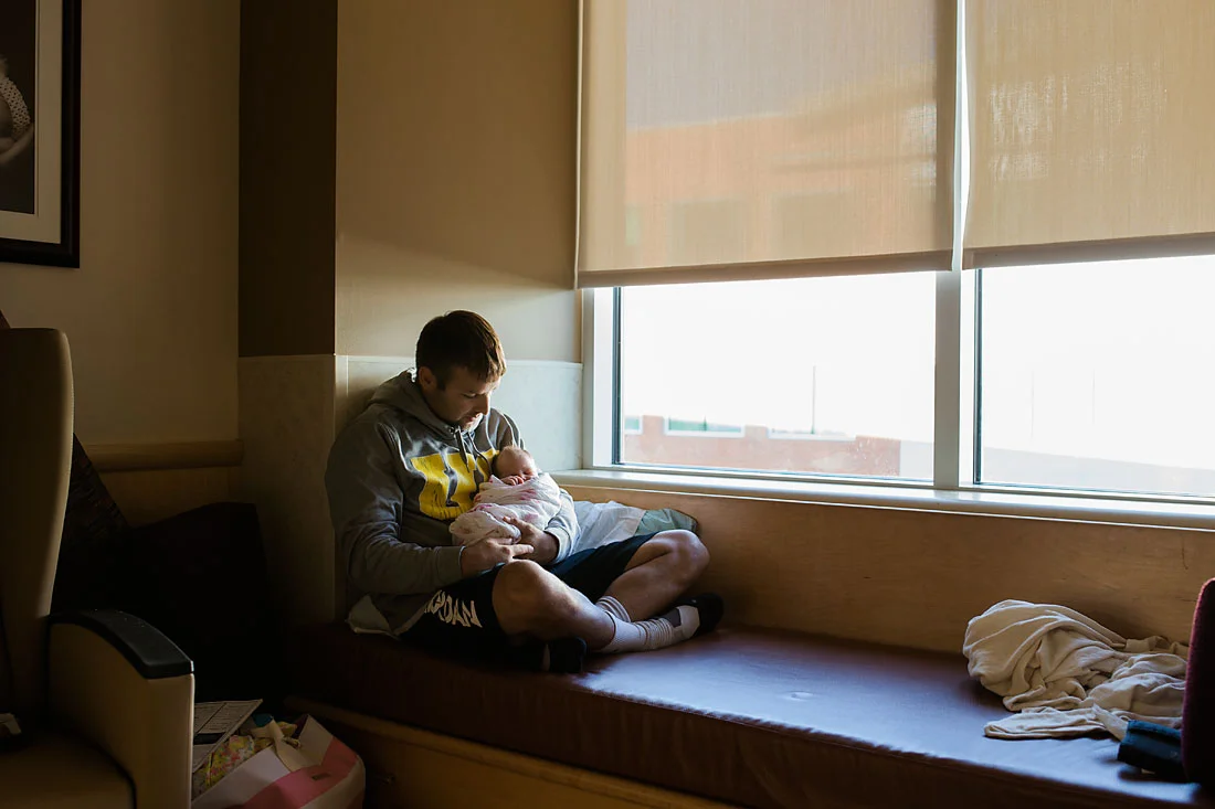 father holding his new baby girl who is one day old