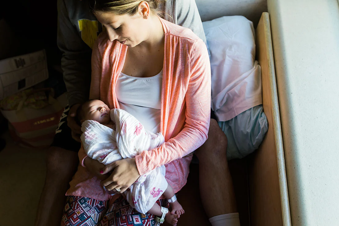 mother holding her one day old daughter in hospital