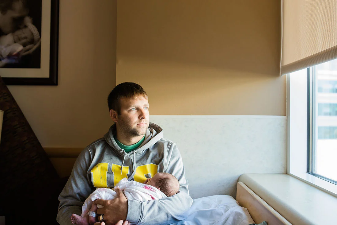 father holding his new baby girl who is one day old