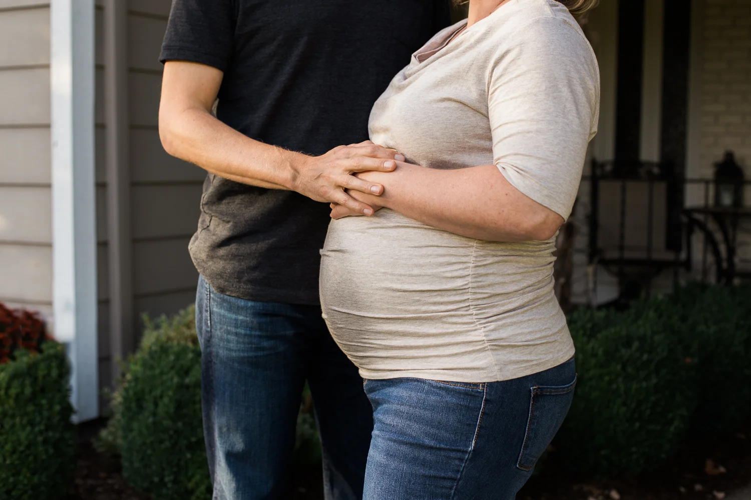 pregnant woman and husband in front yard