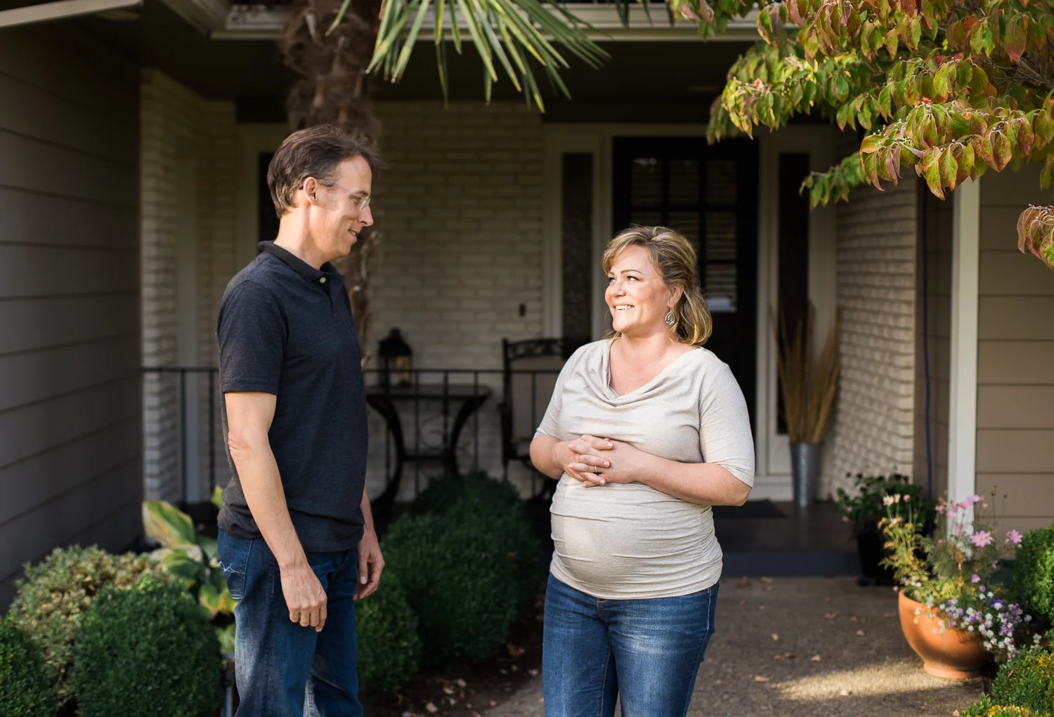 pregnant woman and husband in front yard