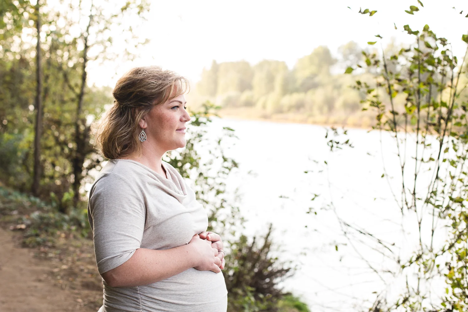 pregnant woman looking out onto the water