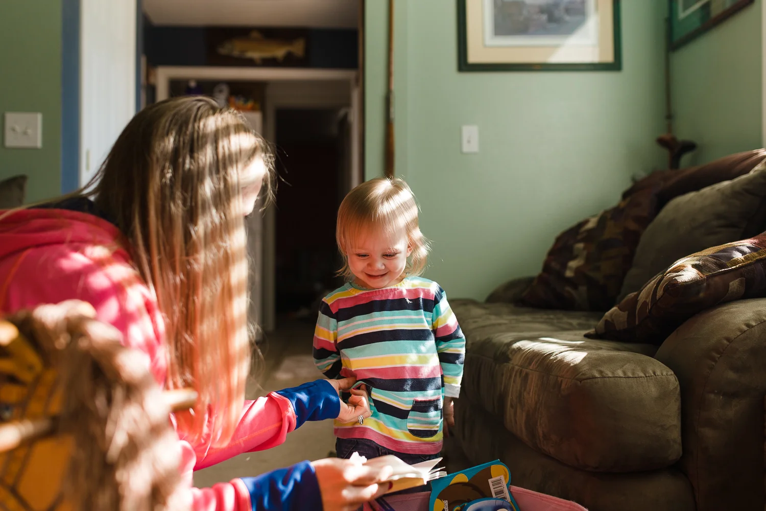 little girl getting tickled by her mom
