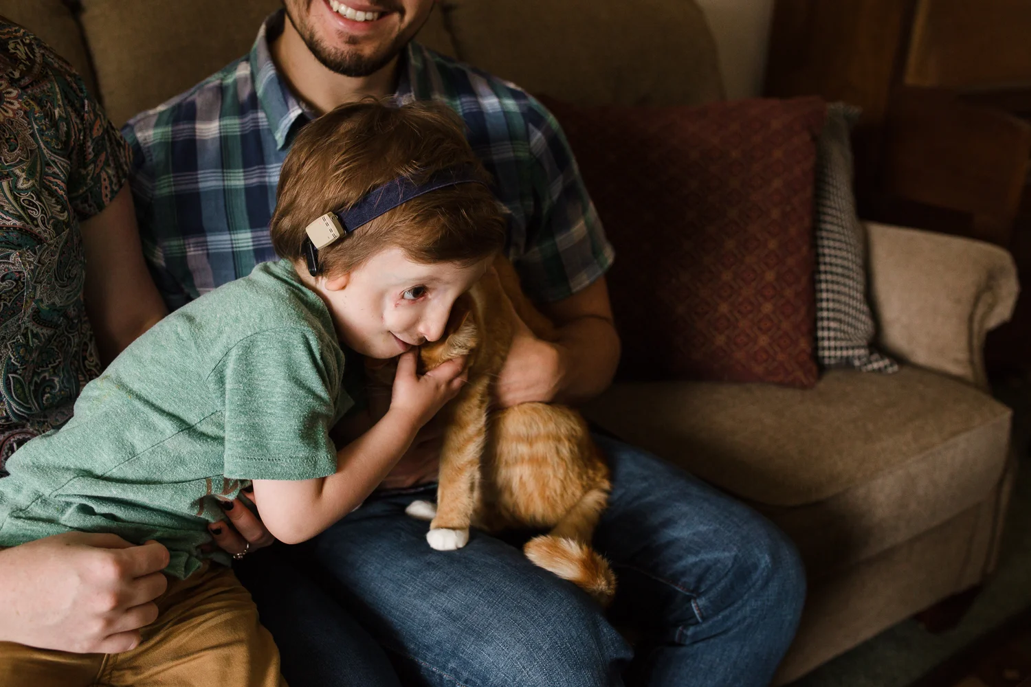 boy hugging orange cat
