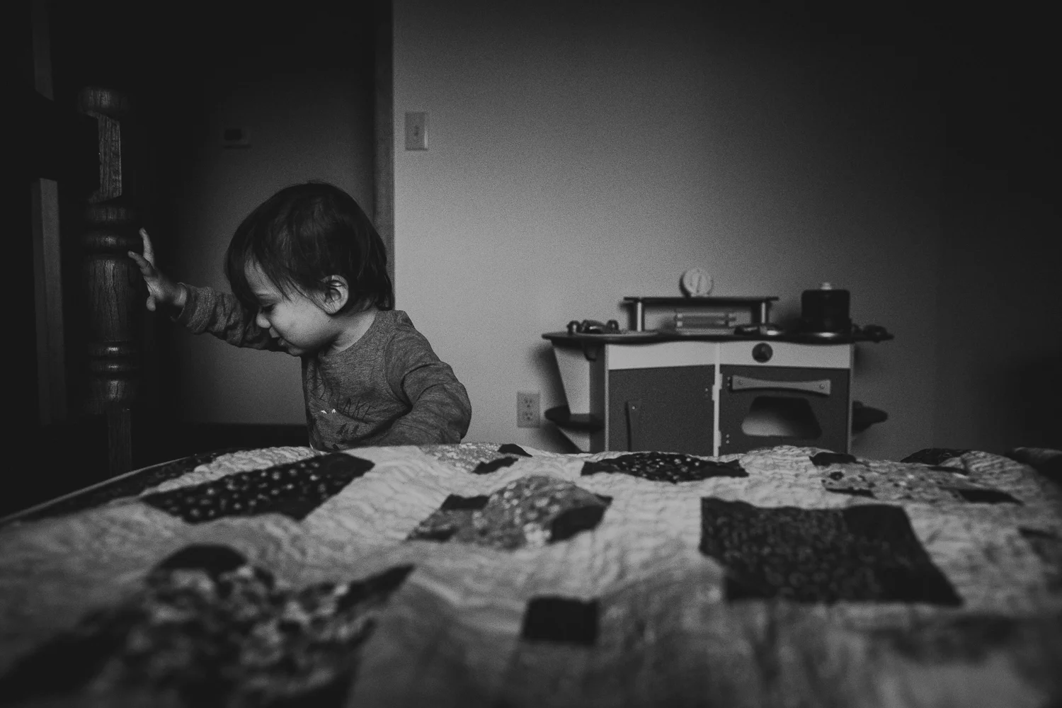 toddler boy climbing on bed