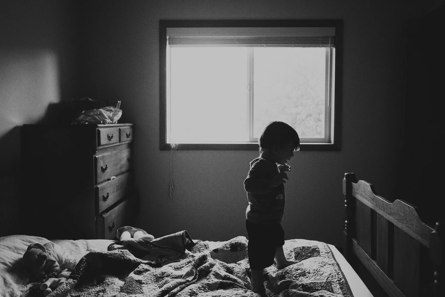 toddler boy walking on bed