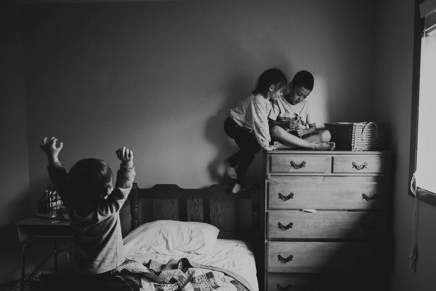 brother and sister playing on bed