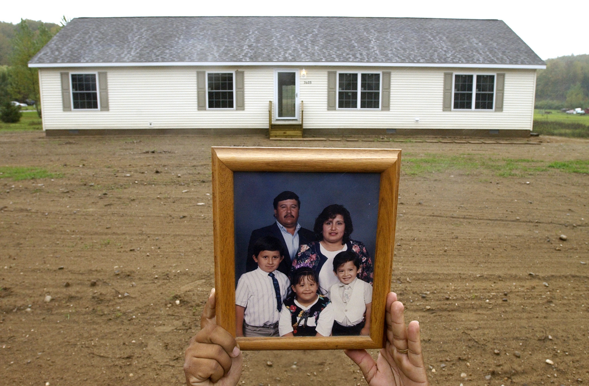 Jessie Reyes holds up an old family portrait of his wife Isabel and three children. The family recently purchased 2.6 acres of property and had a 2,000 square foot home built near Suttons Bay. Jesus and Isabel have spent over 20 years migrating from the Rio Grande Valley of Texas to the fields of Michigan. Isabel moved to over 30 schools as a child and the couple decided after finding steady work and sending their eldest boy to college that they would permanently settle in Suttons Bay. "I think I'll stay here in Michigan for the rest of my life," Jessie said. "It's a better life for me and my children."