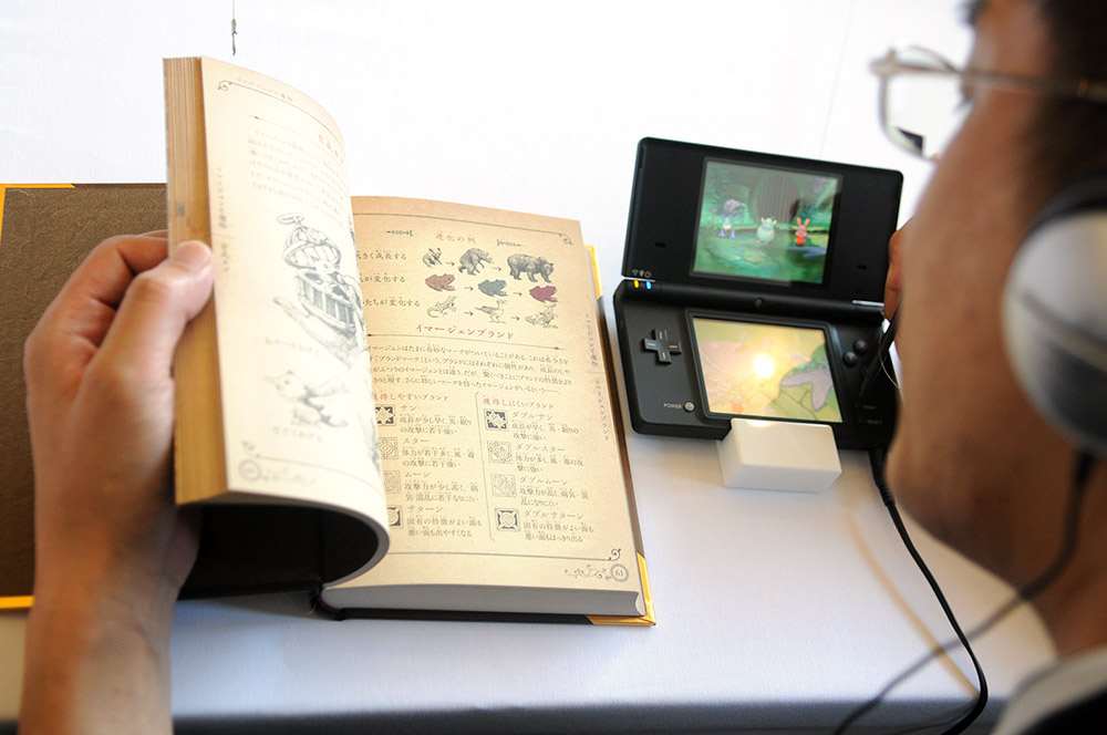 A video game enthusiast plays Ninokuni on the handheld video console Nintendo DS on Thursday in Tokyo. The game incorporates a 352-page book of magic to help players beat the game.