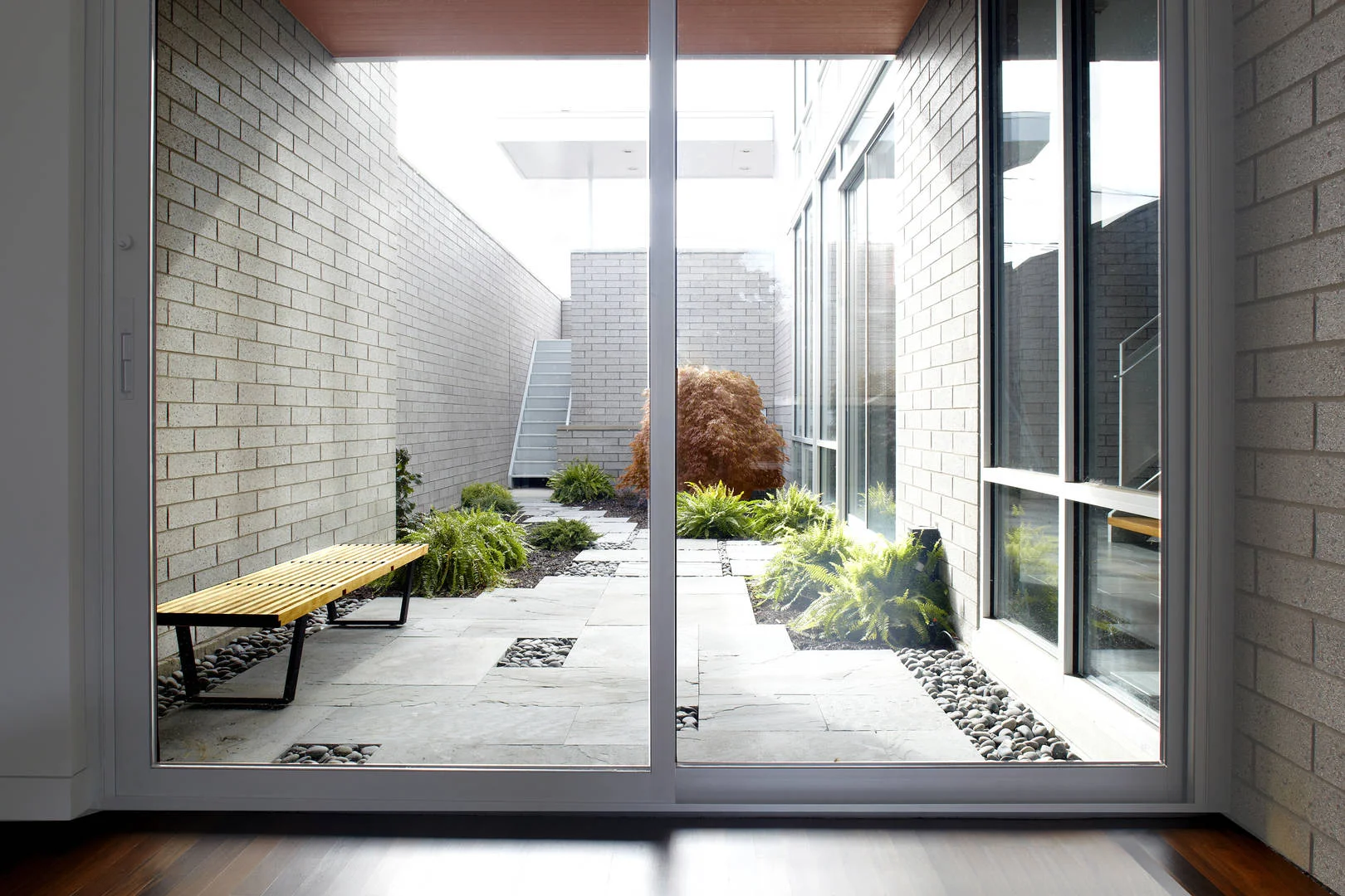 3701 S Parnell Single-Family Home Location: Chicago, IL Photos: Marty Peters Project Description: “Transparent Glimpses” In this residence, the standard organization of main public levels on the first floor and private bedroom levels on the upper floors was re-envisioned. Instead, the main public level was pushed to the top floor and designed as an open plan to take advantage of the natural light and city views. To keep a connection from the main entry to this level, a large gracious foyer and stair atrium was created and extended through all levels of the residence. The main feature of this residence is the “hidden garden” outdoor space. It is fully enclosed by the residence to one side and 14 foot walls to its neighbors. The hidden garden ties together the interior spaces and the 3 story atrium, while enhancing the penetration of natural light into the residence. The hidden garden is carefully arranged to offer glimpses to by passers on the street.