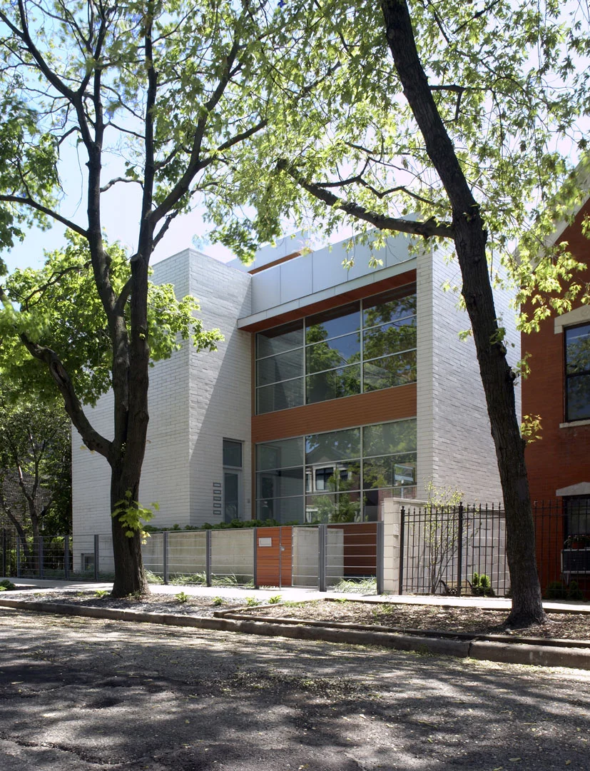 Single-Family Location: Chicago, IL Photos: Marty Peters 2008 Residential Architect Design Award Program This custom residence was created out of the basic elements in architecture-light, shadow, massing, color, transition and how we experience these things. The house was to be a collection of light-play in a tight urban setting. A residential Box Set. The residence is located on a tight urban lot in Chicago's older Bucktown neighborhood. It is for a young urban couple with three young children and a Mother-in-Law. The residence faces north. The size of the house was to be approximately 6500 square feet in area and comprise of 4 levels. The garden level required an office for the owners, a guest suite, den for the kids, an exercise room and spa bath. The first floor required a living room, dining room, kitchen and family room. The second floor was for the master bedroom suite, two kid’s rooms and an open reading loft. The third floor required an entertaining room which includes a kitchen and a full roof deck with views of the city skyline. The owners also requested a series of exterior spaces located on different levels; courtyard, garage roof deck and house roof deck. Solution The design solution started with two cubes, one opaque and one transparent. Both cubes are paired together to create an “L” shape and define an inner courtyard. All rooms face the inner courtyard. Like a Box Set, the transparent cube collects the majority of the light for the residence and allows for views through the residence from the street and other areas of the home. The opaque cube accommodates the more private functions of the residence. This residence is designed using very simple strategies. The exterior is clad in only two materials; white ground face masonry and cedar. The white masonry creates open and light filled interiors while the cedar is used as natural, softening accent. Both materials extend to the interiors to create subtle contrasting surfaces and blur the boundary between the exterior and the interior. The second floor ceiling of the transparent cube is clad in cedar that extends through the house, projecting out each side, providing sun protection.