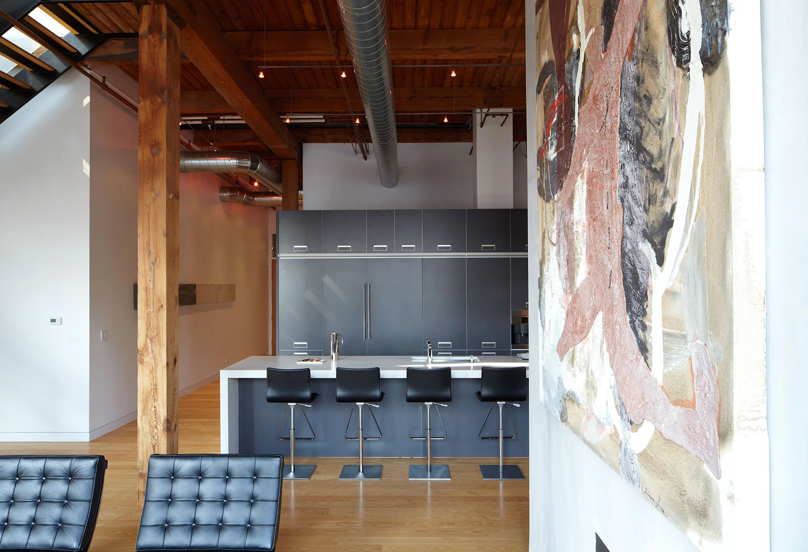 Single-Family Location: Chicago, IL Photos: Marty Peters "Loft & Found" This renovation of two existing loft warehouse dwelling units resulted from a need for a family to expand and take advantage of the spectacular views. The previous loft was small with a tight spiral stairs to a small rooftop room. Attached was a small roof deck surrounded by a sea of flues and vents all of which overlooked a skyline view. A new large centrally located kitchen was created to serve as the units “anchor”. The kitchen is comprised of two elements; a tall wall section that houses all the appliances and serves as a screen to the rear spaces, and a long island that provides generous space for seating and cooking. A new glass lined staircase was created up to a newly expanded penthouse. A large deck and trellis was created outside with ample landscaping, all adding to the dramatic skyline experience.