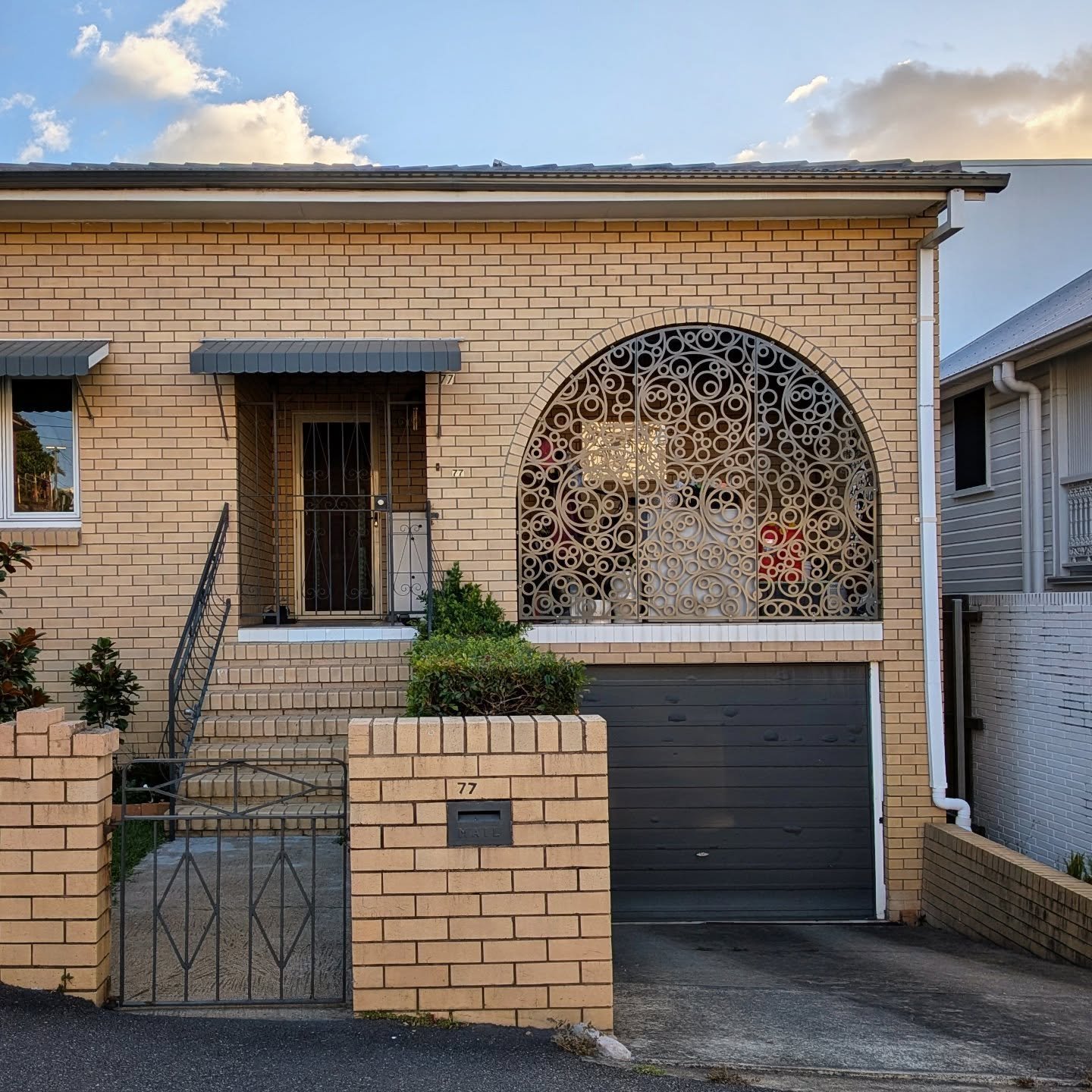Hard to pin this one down. Not really a Queenslander but maybe 1960s brick original with 2010s update of a squiggly latticed verandah. Kinda like it