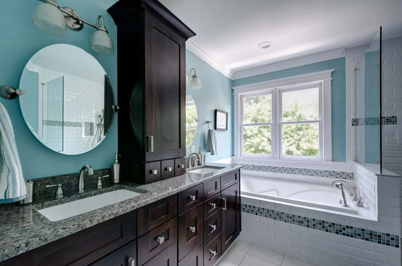 Blue Bathroom with Cherrywood Shaker Cabinets, subway tiles and oval mirror