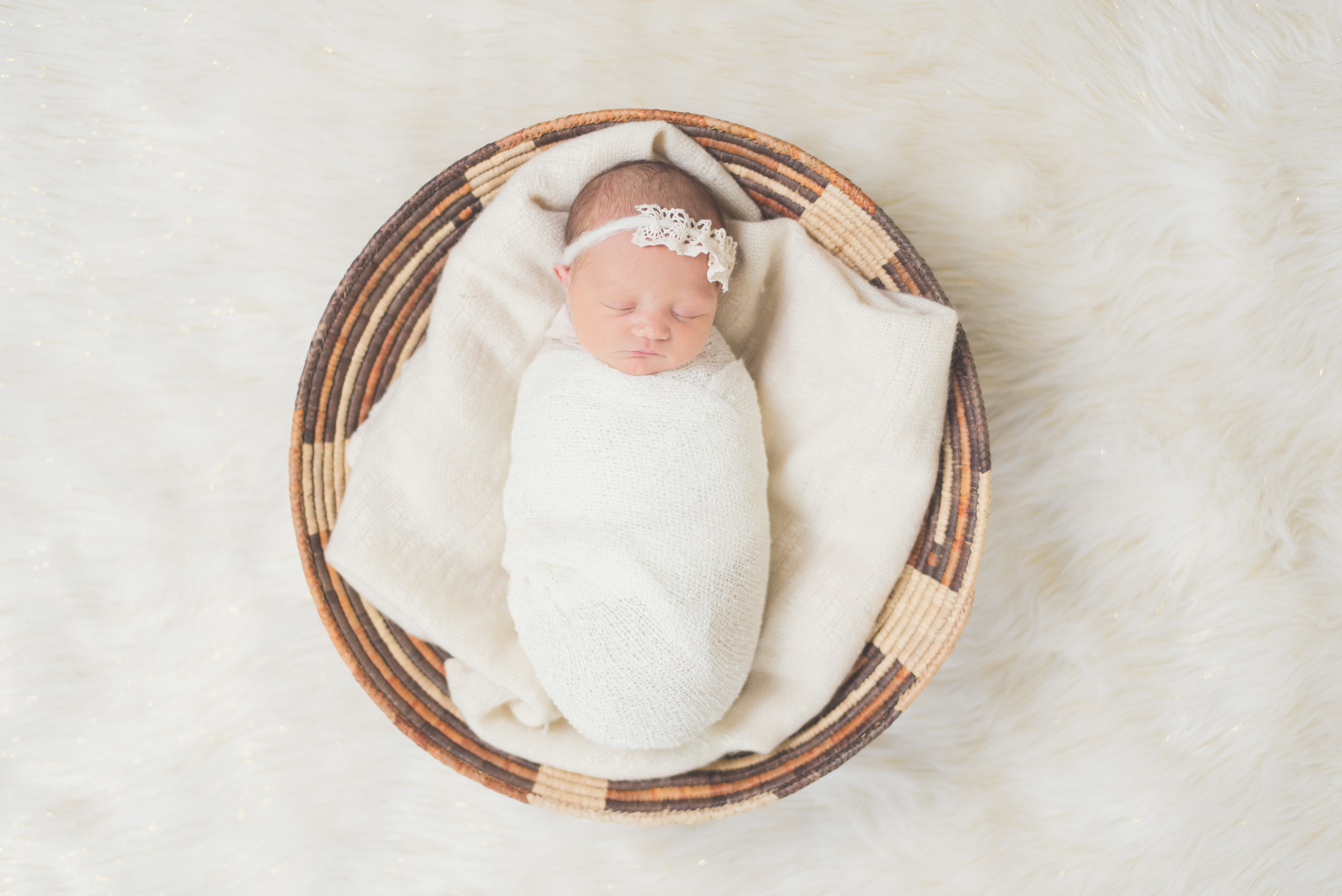 baby girl in basket neutral colors