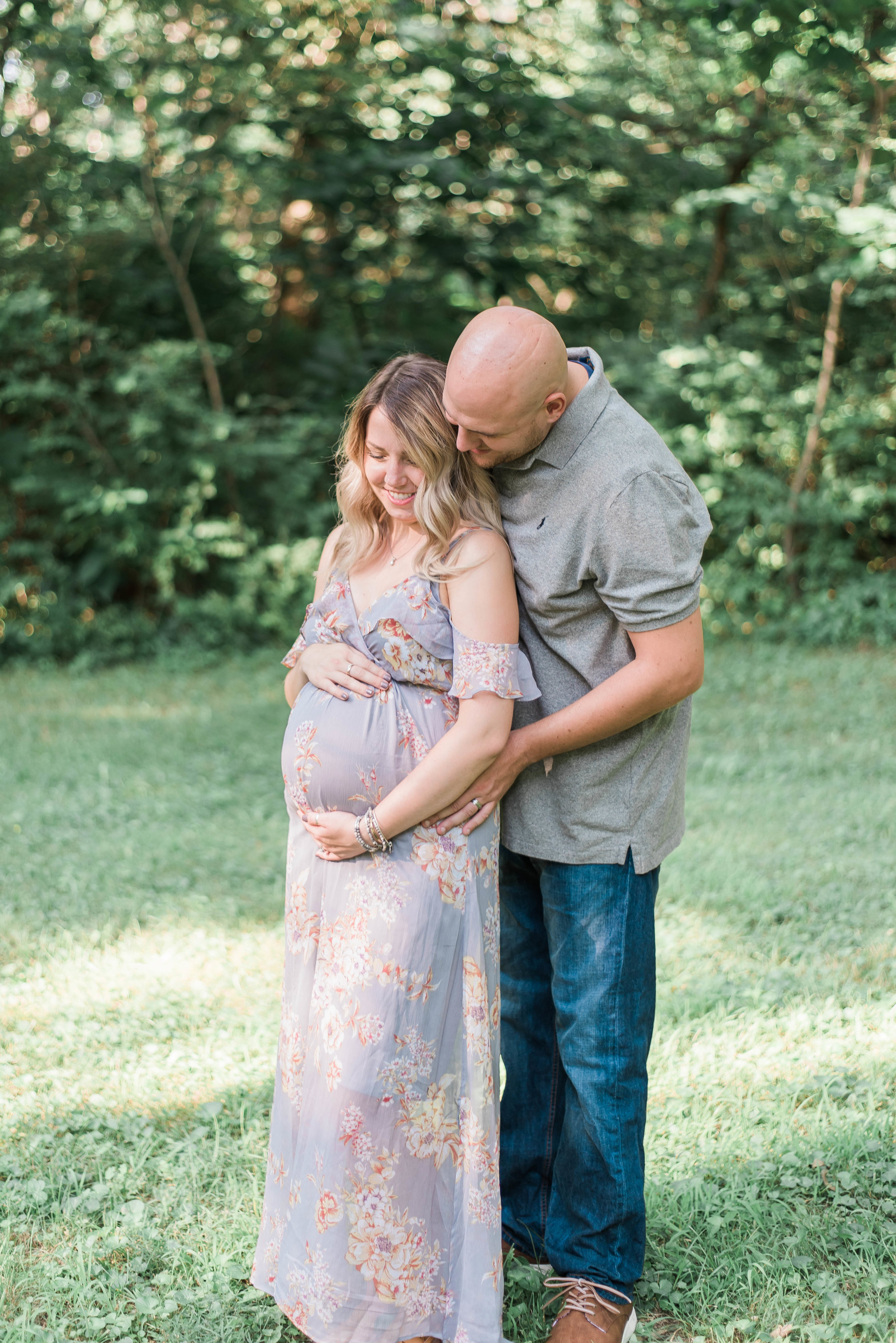 mom and dad snuggle maternity picture outside