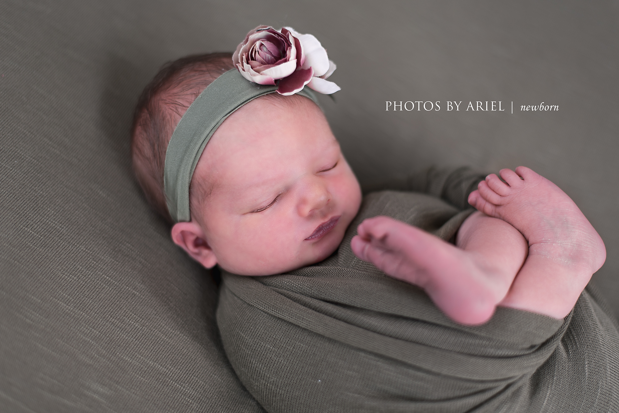 newborn girl with feet hanging out