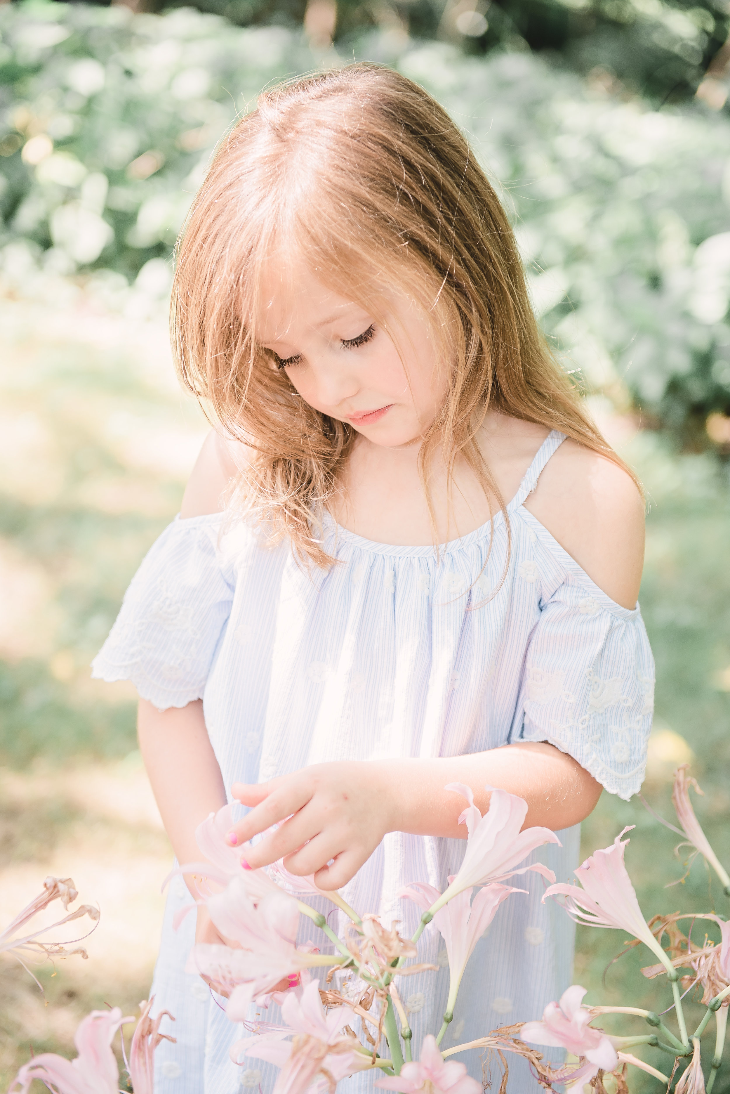 little girl staring at flowers 