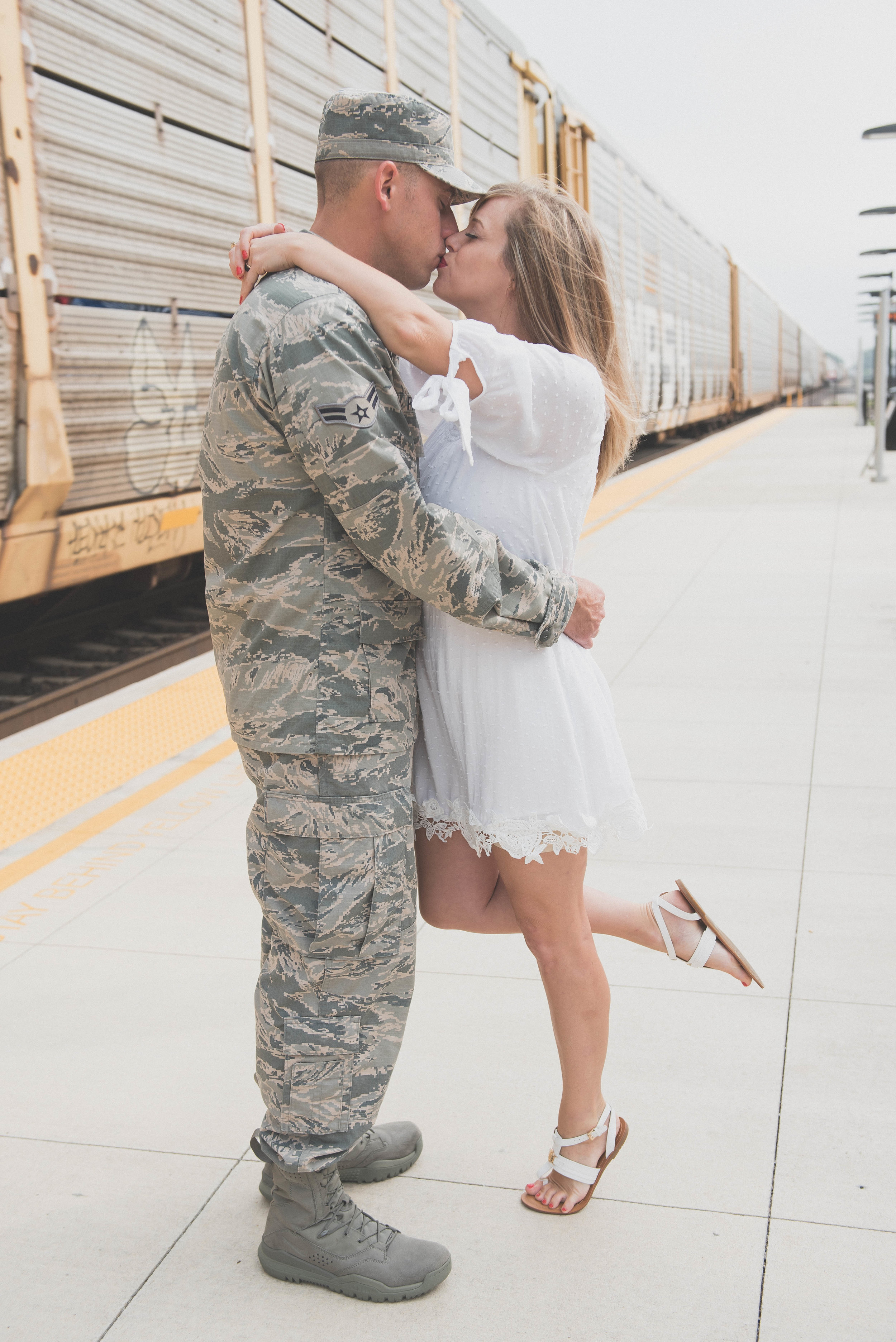 military kiss in front of train