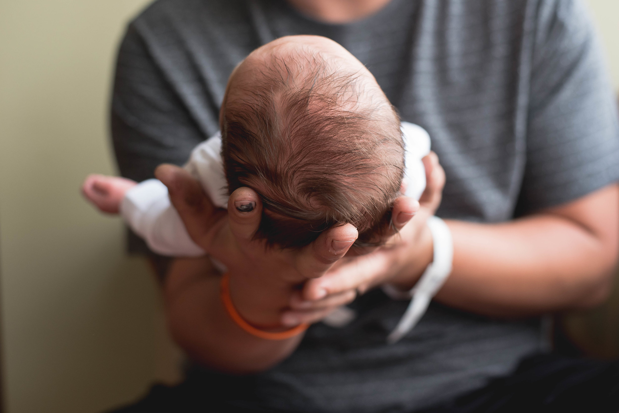 dad hands behind babys head