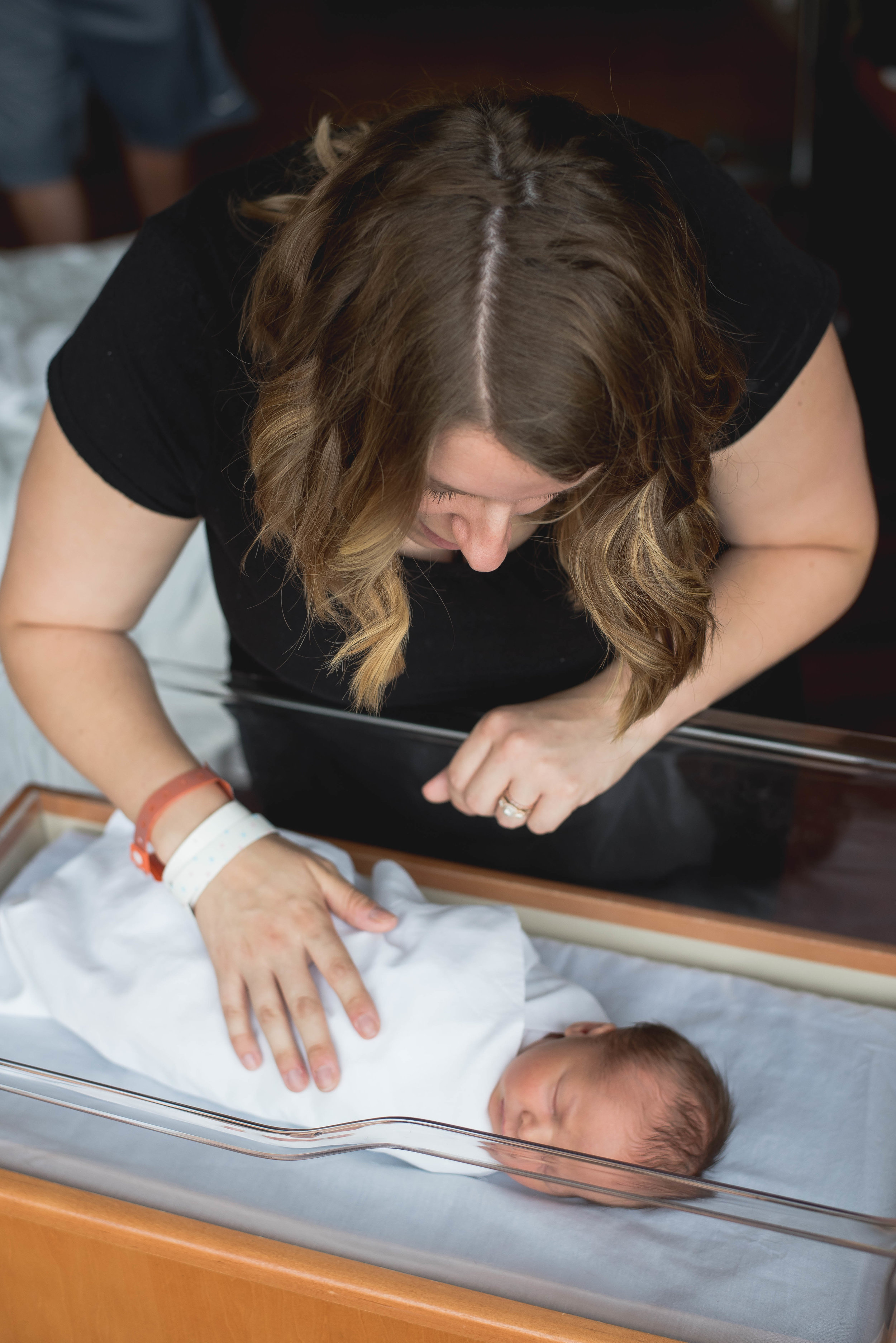 mom with baby in bassinet