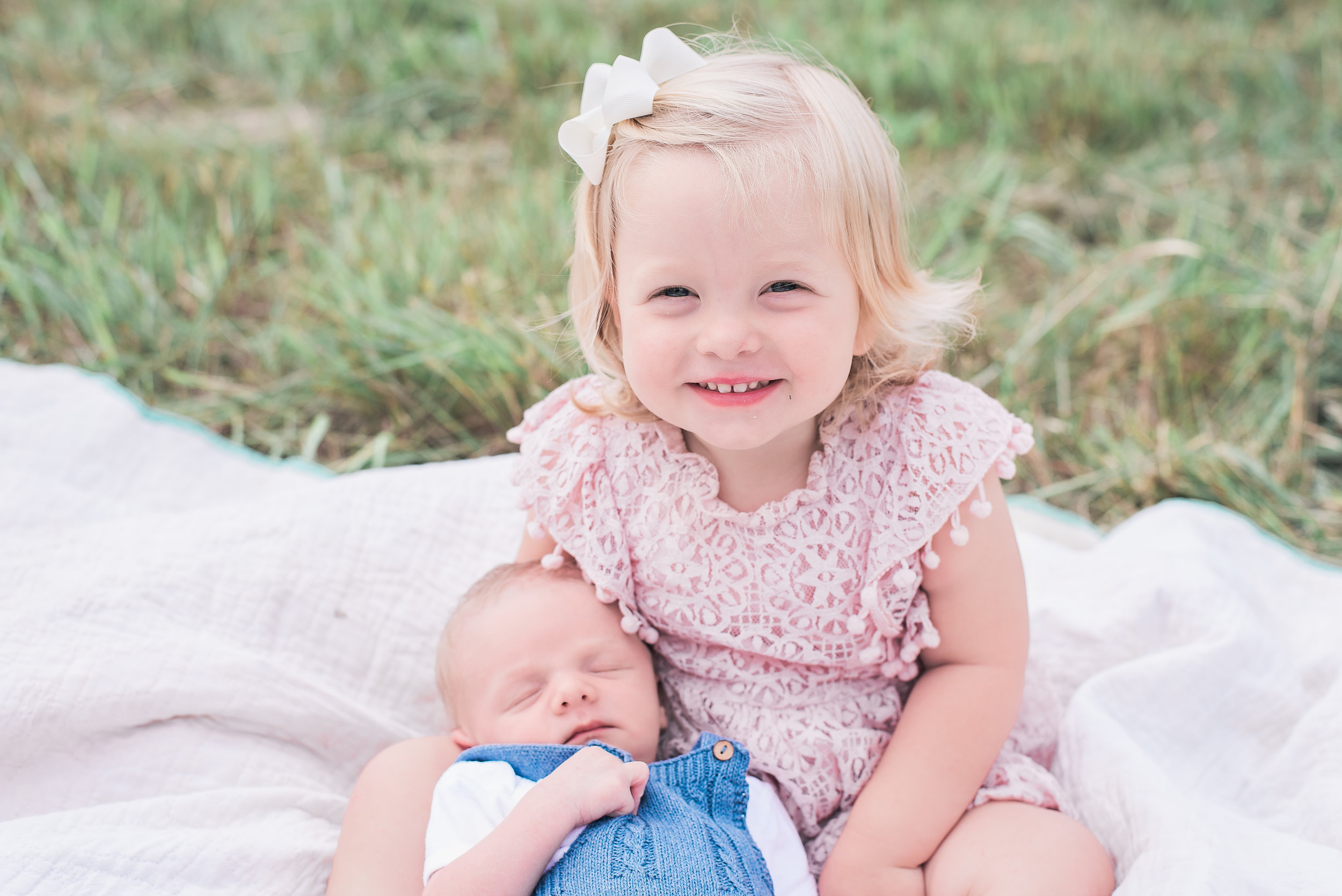 newborn sibling shot outdoors