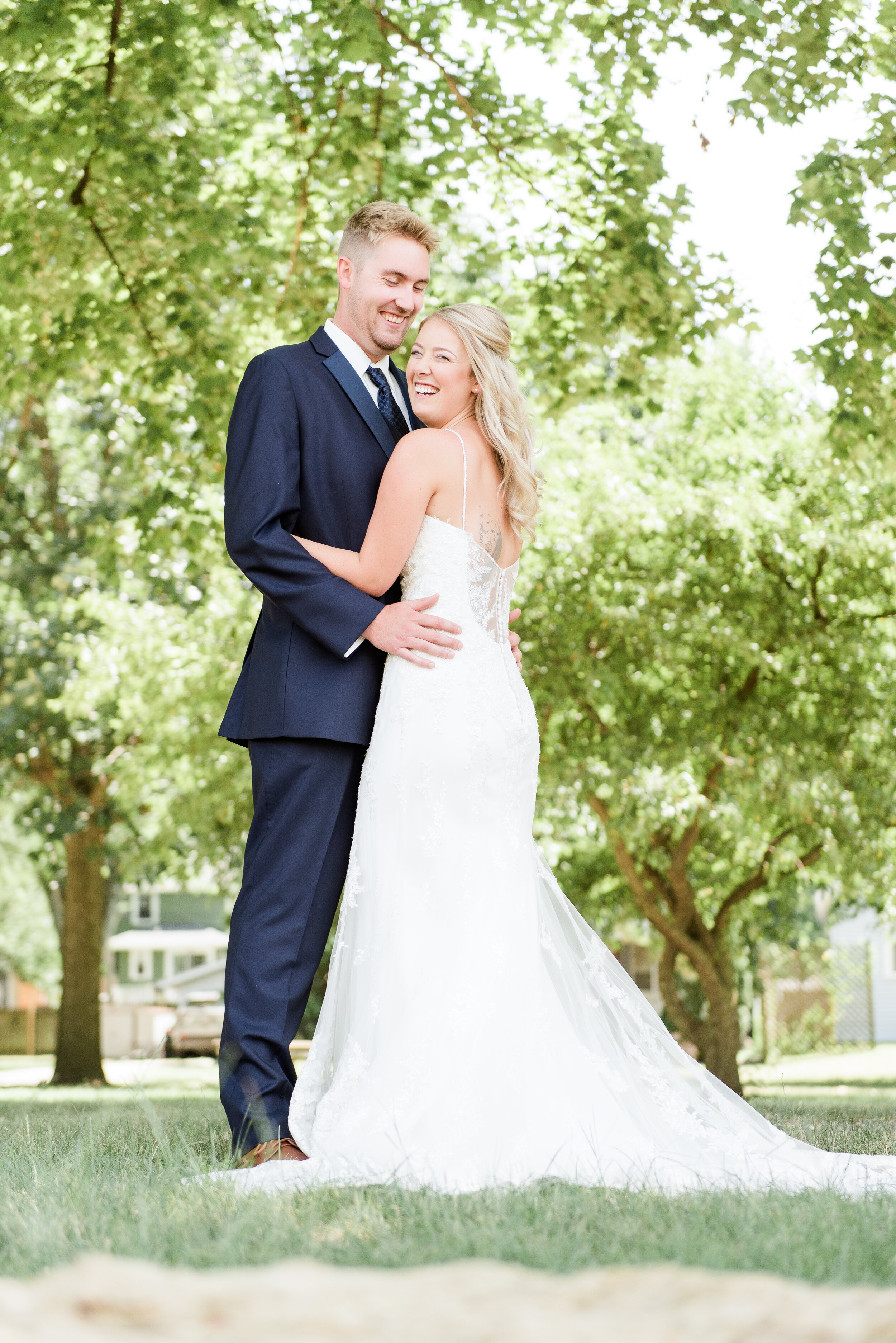 bride and groom laughing in grass 