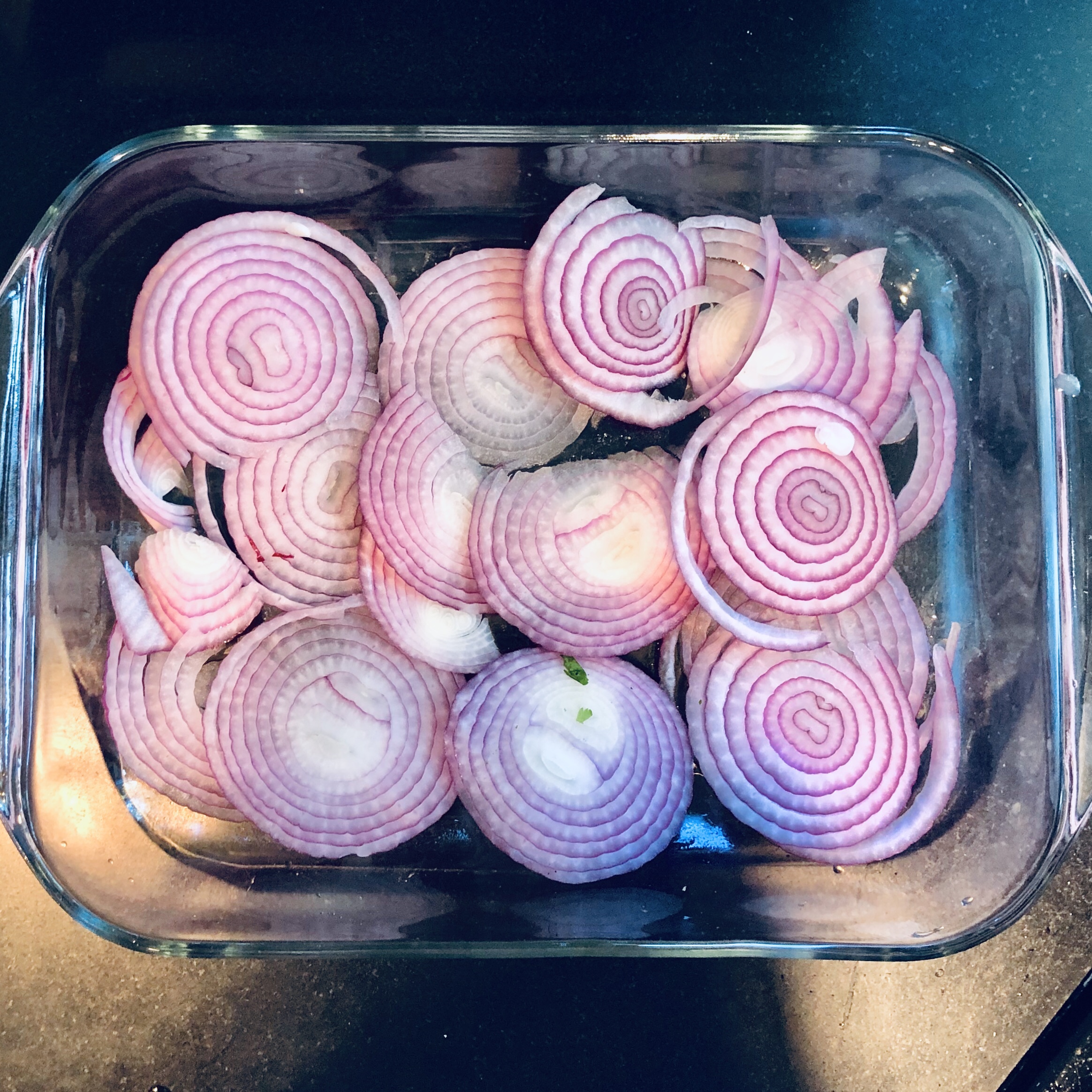 2. Grease a large casserole dish with olive oil and cover the bottom with sliced red onions. Pour more olive oil over the top of the onions. 3. Place the whole fish on top of the onion slices and generously brush Its top, bottom, and inside cavity with olive oil.