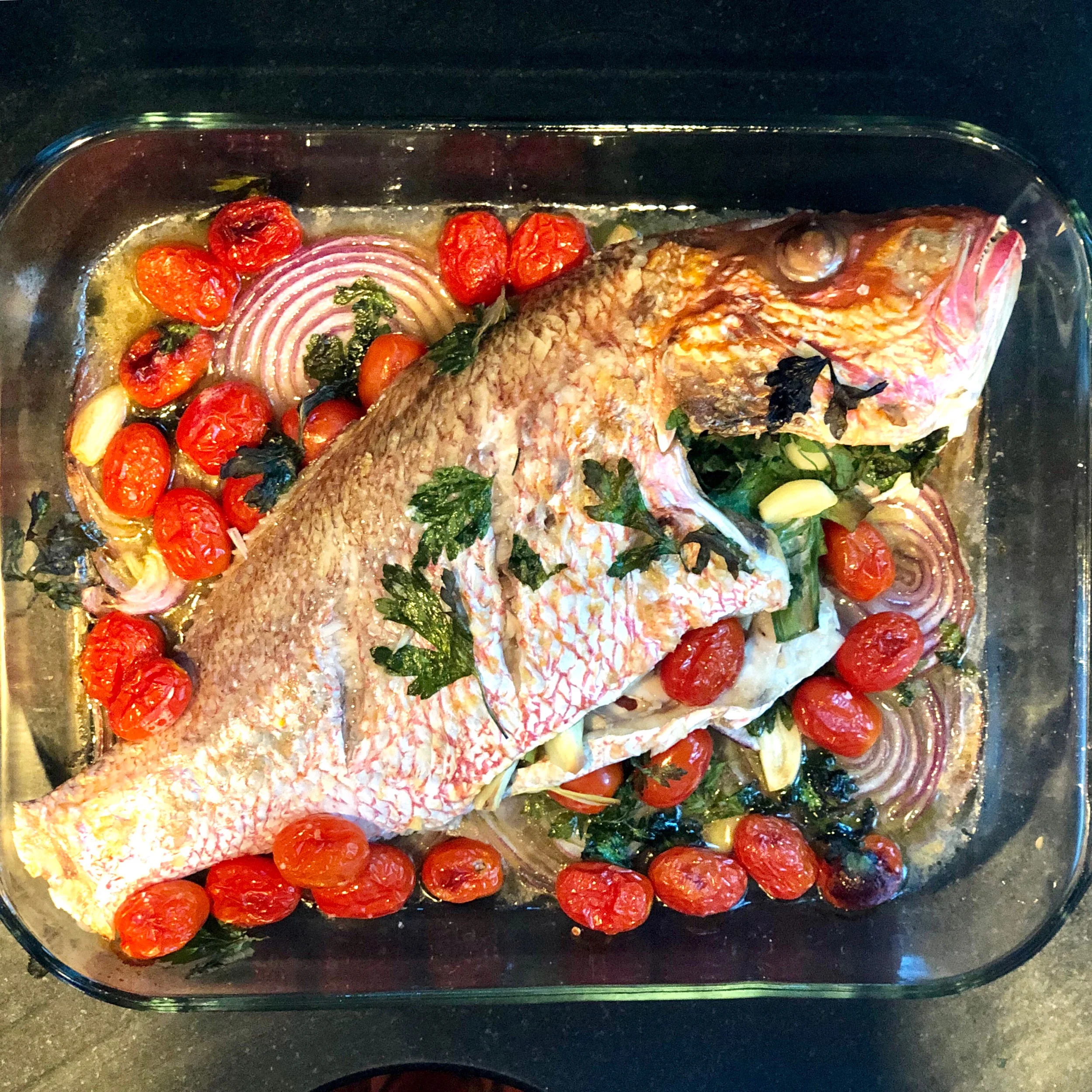 10. Once your timer has chimed after 25-30 minutes, turn your oven to broil and leave the fish in for another 5-7 minutes, until the top has browned a bit. 11. Remove the fish from the oven and debone it on a large wooden cutting board.