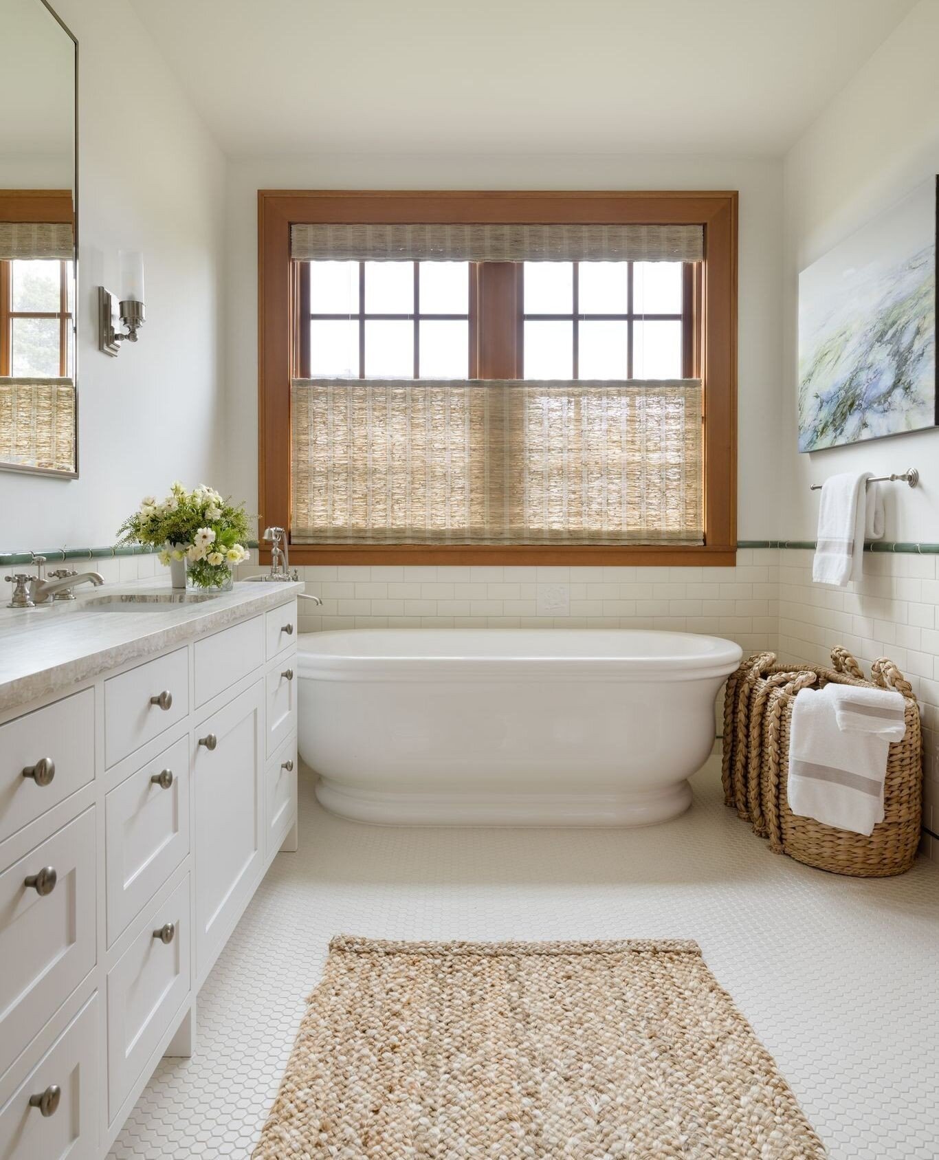 Situated on the water, our Puget Sound Residence project represents all the elements of a beach house. This serene bathroom was made more natural with grass shades, jute rug and a sweater weave basket which add beautiful texture to the room. We place