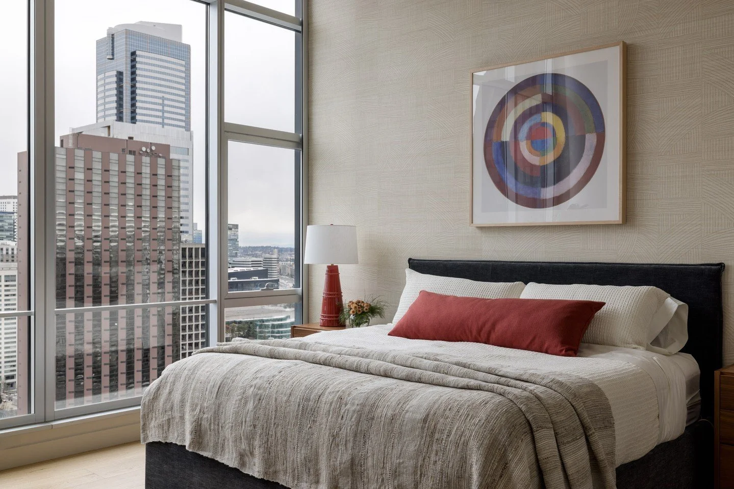 Above the hustle and bustle of the city, we crafted a serene primary retreat in our Seattle Skyline Project. The client&rsquo;s favorite color is incorporated in the bedroom lamps and bedding accents, while the room is primarily restful and airy. We 