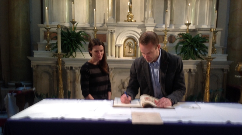 JERRE RIGGS, CATECHUMEN, SIGNING THE "BOOK OF THE ELECT"