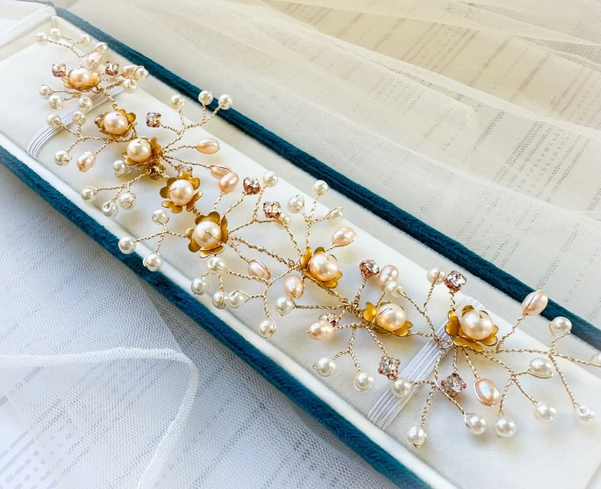 pearl bridal hairvine laid on top of a blue velvet case.