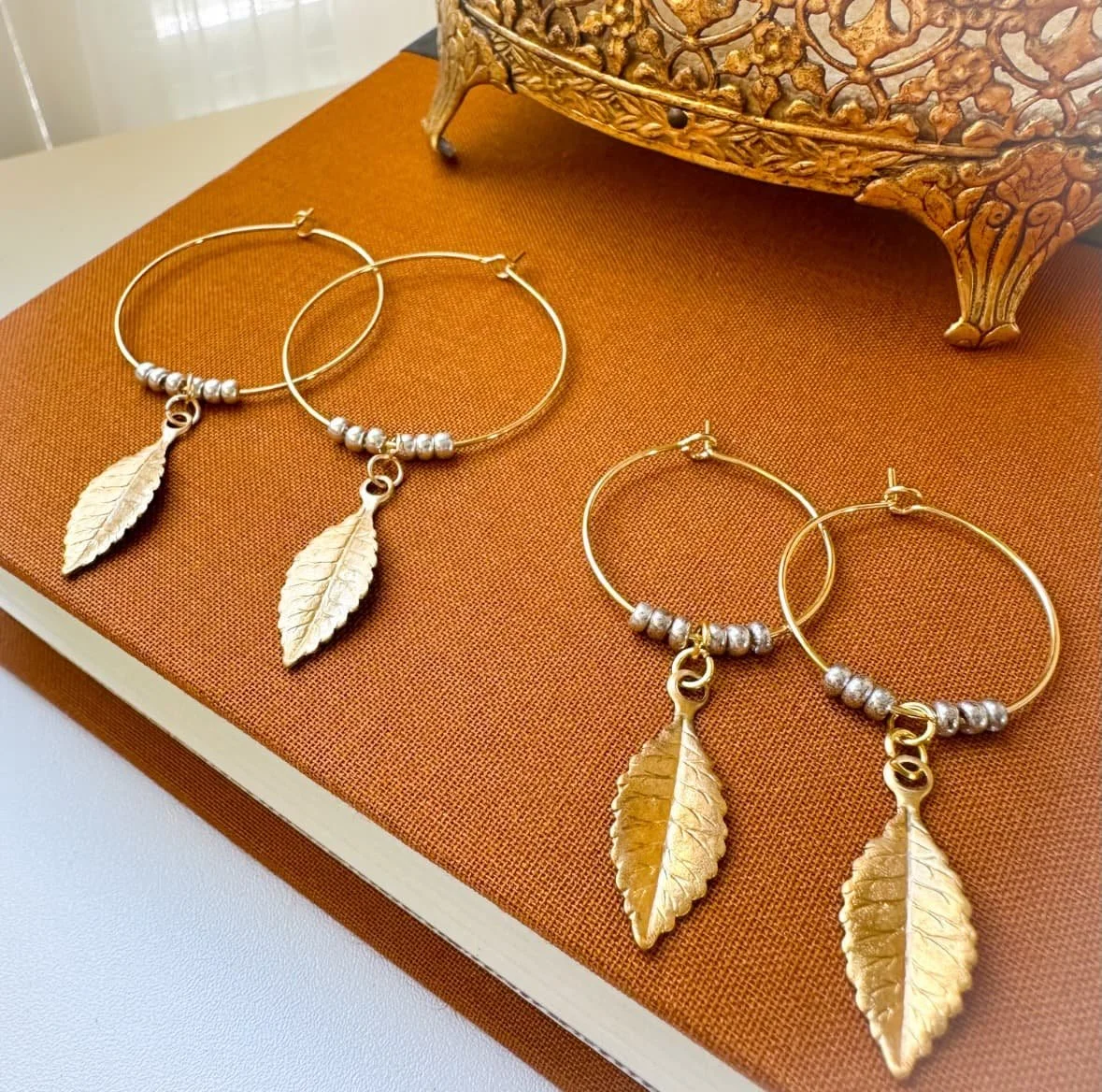 Large and small hoops with brass leaves hung from them.