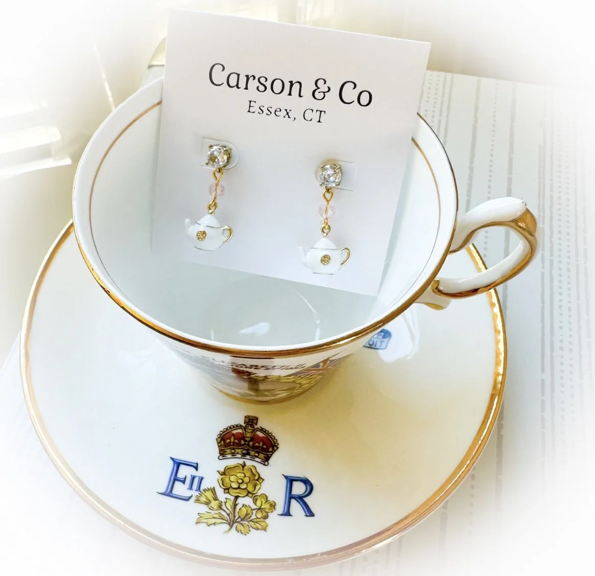 white teapot earrings in an Elizabeth II teacup and saucer